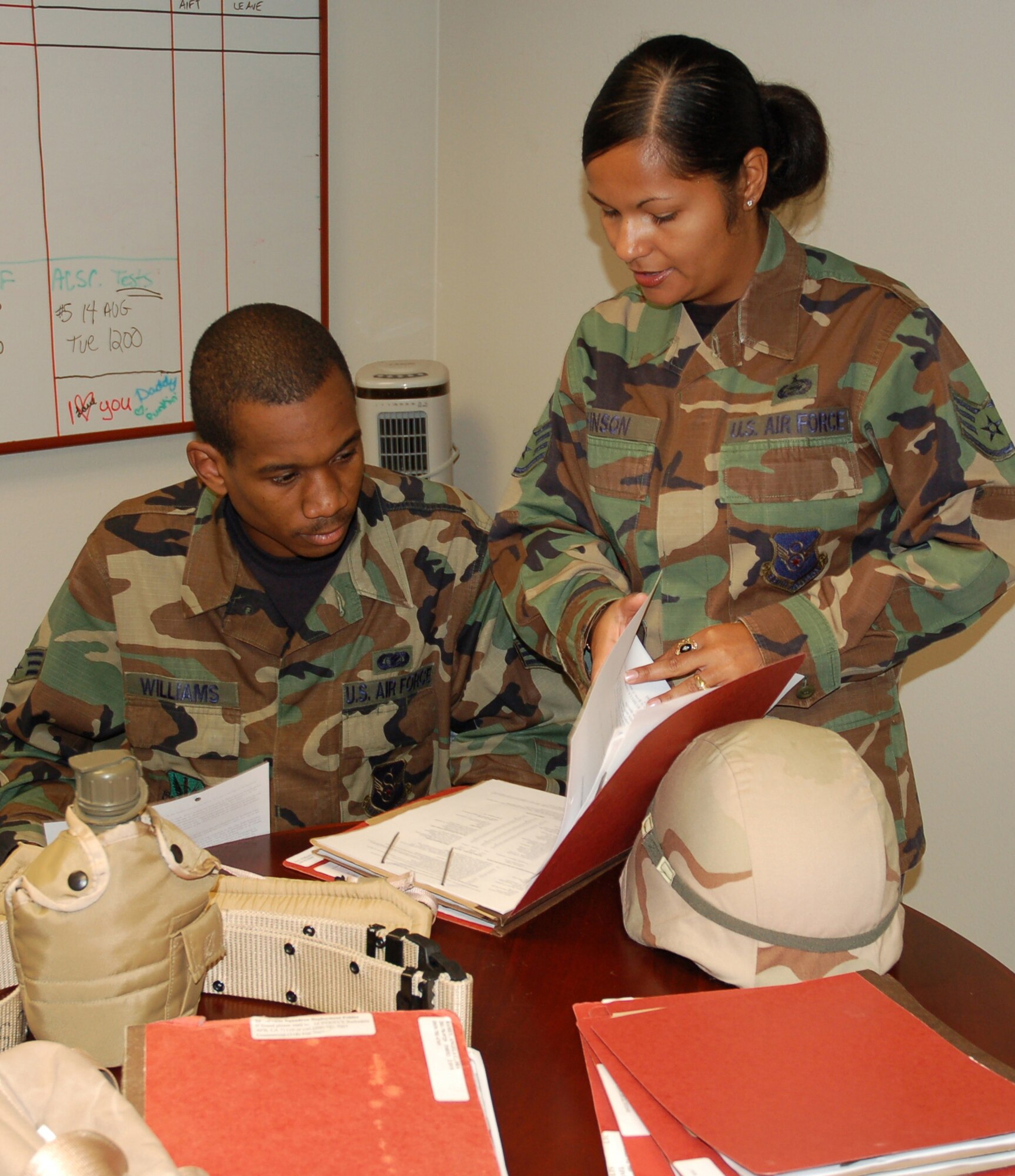 Staff Sgt. Brenda Johnson explains deployment requirements to Senior Airman Christopher Williams.Sergeant Johnson put her self aid and buddy care skills to work during a temporary duty helping victims of a car accident. She is a Unit Deployment Manager for Eighth Air Force. (U.S. Air Force photo by Tech. Sgt. Kristina Barrett)