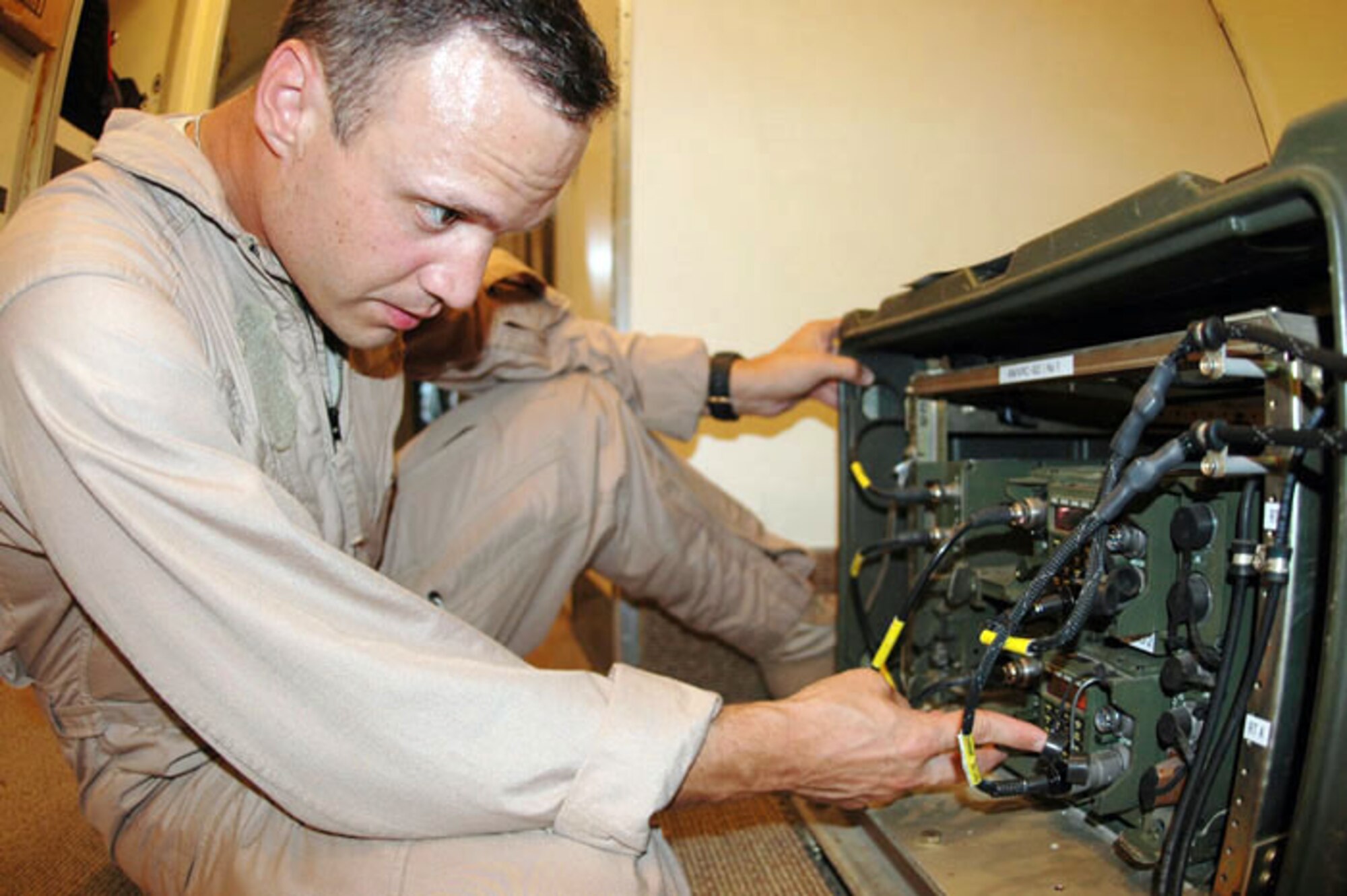 Navy Petty Officer 2nd Class Kasey Bruce performs routine maintenance on an E-6B Mercury prior to its flight over Iraq in July in Southwest Asia. Petty Officer Bruce, assigned to Task Force 124, is deployed here from Tinker Air Force Base, Okla. (U.S. Air Force photo/Senior Airman Clark Staehle)