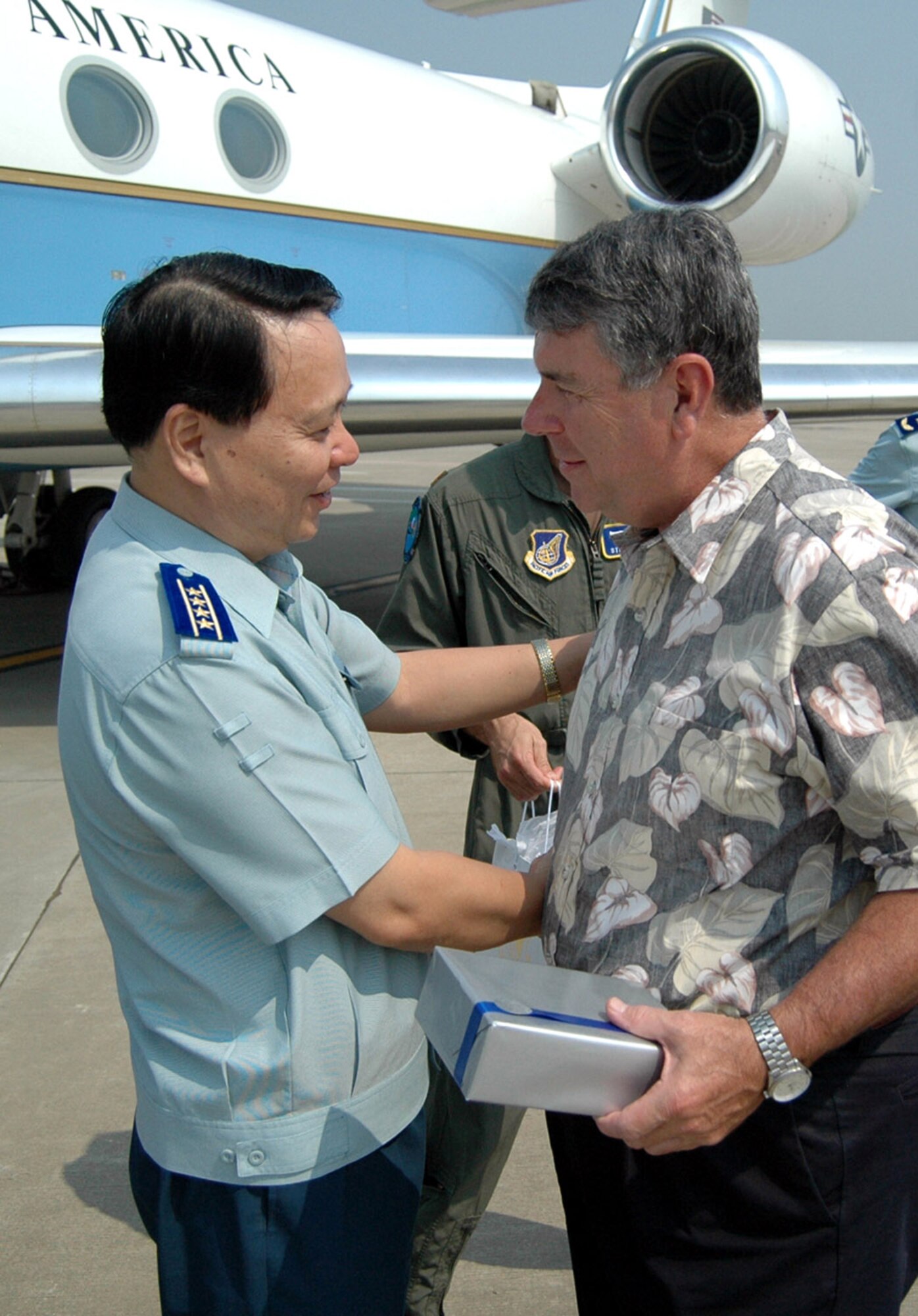 Gen. Paul V. Hester presents a gift to Chinese Senior Col. Duan Xiaoming July 28 at the Nanjing Lukou Airport in China. General Hester is the commander of Pacific Air Forces. The rank of senior colonel is equivalent to brigadier general. Senior Colonel Xiaoming is the senior liaison officer to the People's Liberation Army Air Force and deputy director of the Headquarters People's Liberation Army Air Force General Office. (U.S. Air Force photo/Maj. Ray Truong) 

