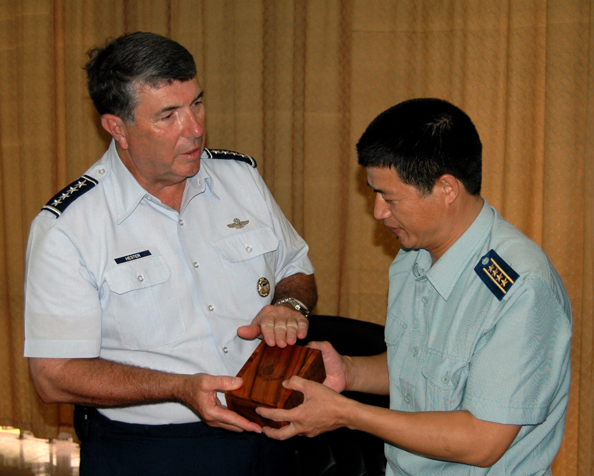 Gen. Paul V. Hester explains the symbolism of Pacific Air Forces on an engraved koa wood box as he presents it to Chinese Senior Col. He Quanshou July 24 at Jianqiao Air Base, China. General Hester is the PACAF commander, and Senior Colonel Quanshou is the commander of the 28th Air Division, People's Liberation Army Air Force. (U.S. Air Force photo/Maj. Ray Truong) 
