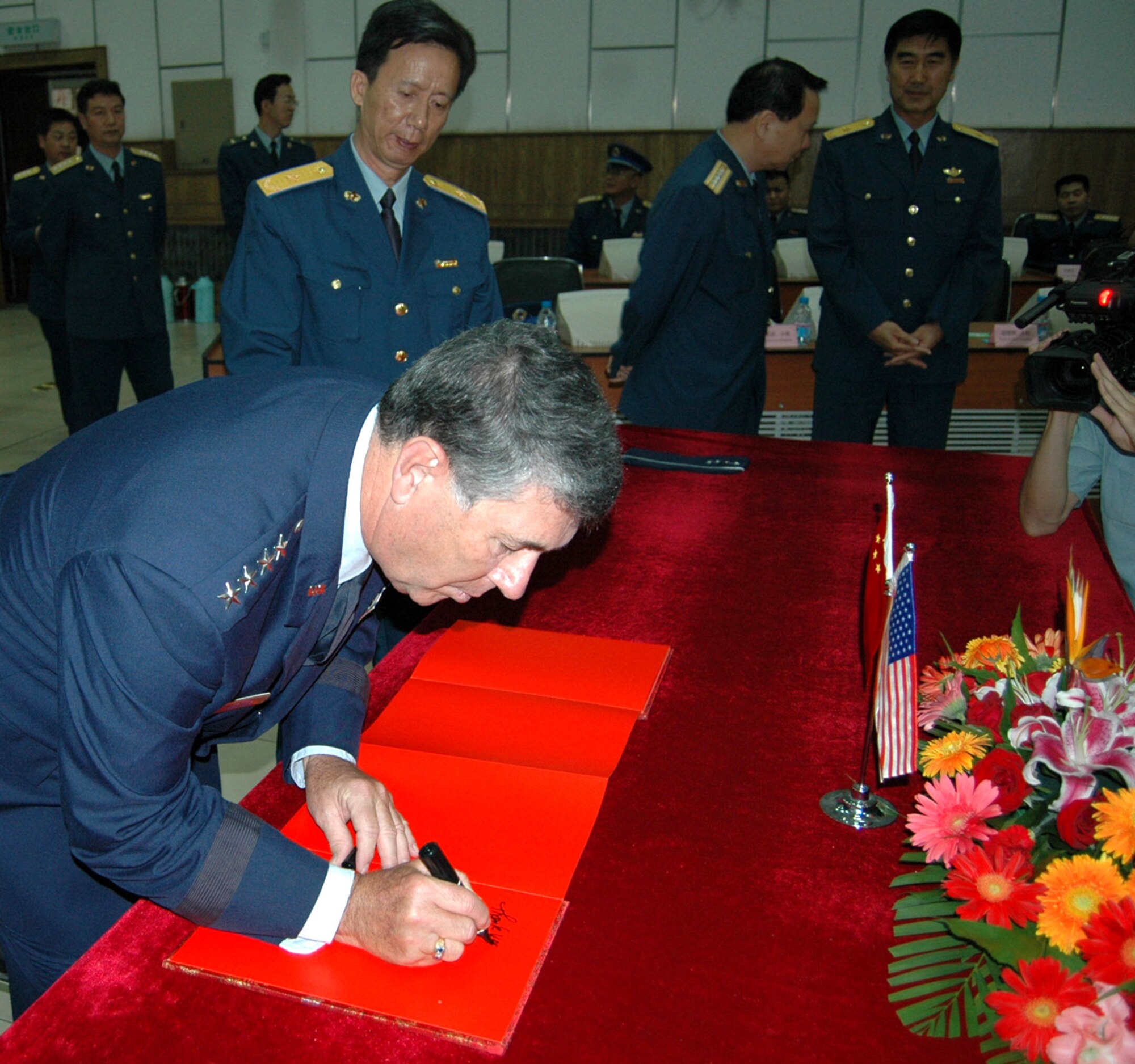 Gen. Paul V. Hester signs a guest book as Maj. Gen. Zhong Wanfu looks on July 24 at the People's Liberation Army Air Force Command College in Beijing. The command college is the People's Liberation Army Air Force's highest professional military education school and has students ranging from captain to senior colonel, the equivalent of an American brigadier general. General Hester is the commander of Pacific Air Forces, and General Wanfu is the People's Liberation Army Air Force Command College deputy commandant. (U.S. Air Force photo/Maj. Ray Truong)