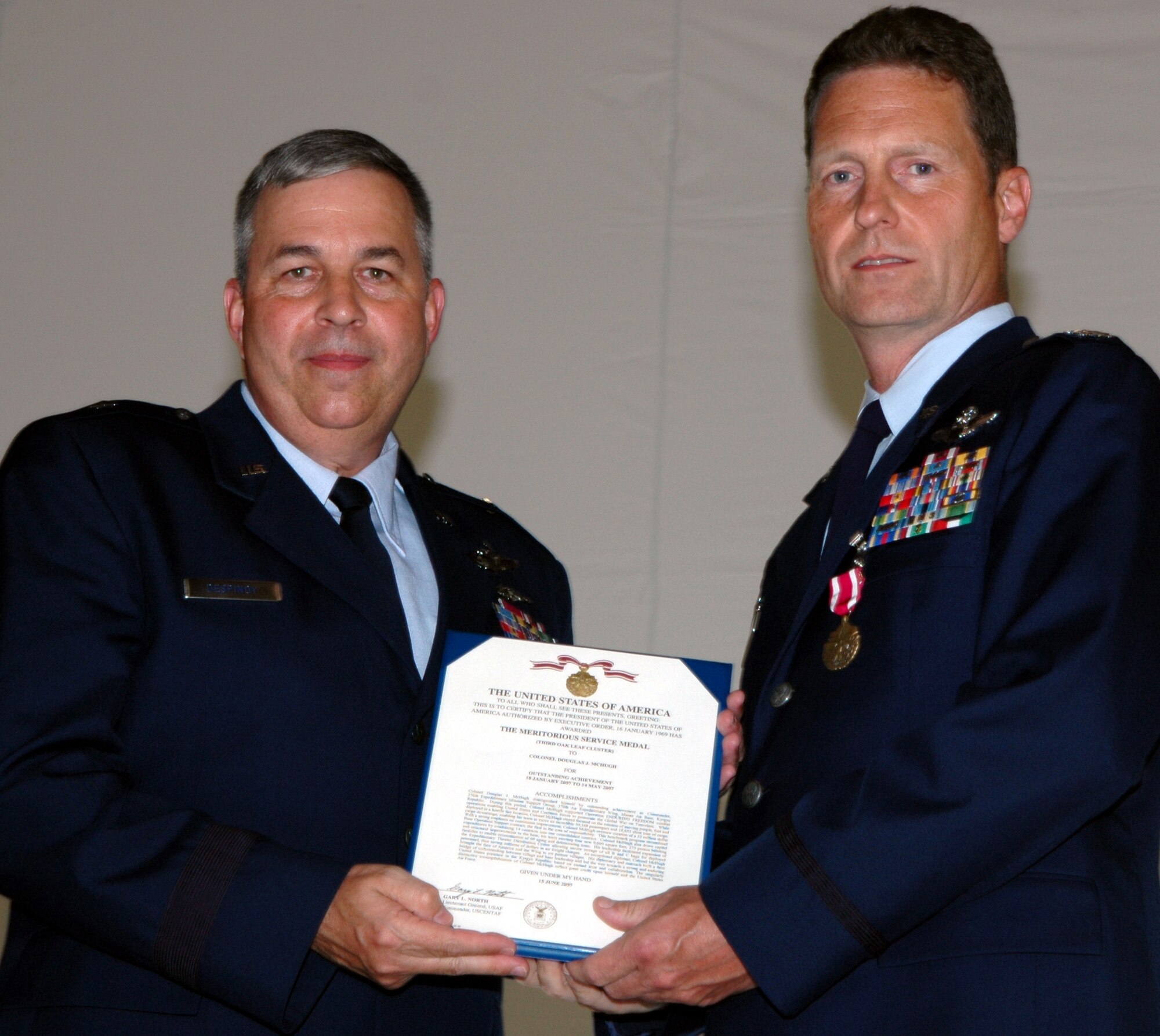 GRISSOM AIR RESERVE BASE, Ind., -- Brig. Gen. Dean Despinoy, 434th Air Refueling Wing commander, left, presents Col. Doug McHugh, 434th Mission Support Group commander the Meritorious Service Medal. Colonel McHugh received the medal for his actions during a deployment in support of Operation Enduring Freedom. (U.S. Air Force photo/Tech. Sgt. Doug Hays)