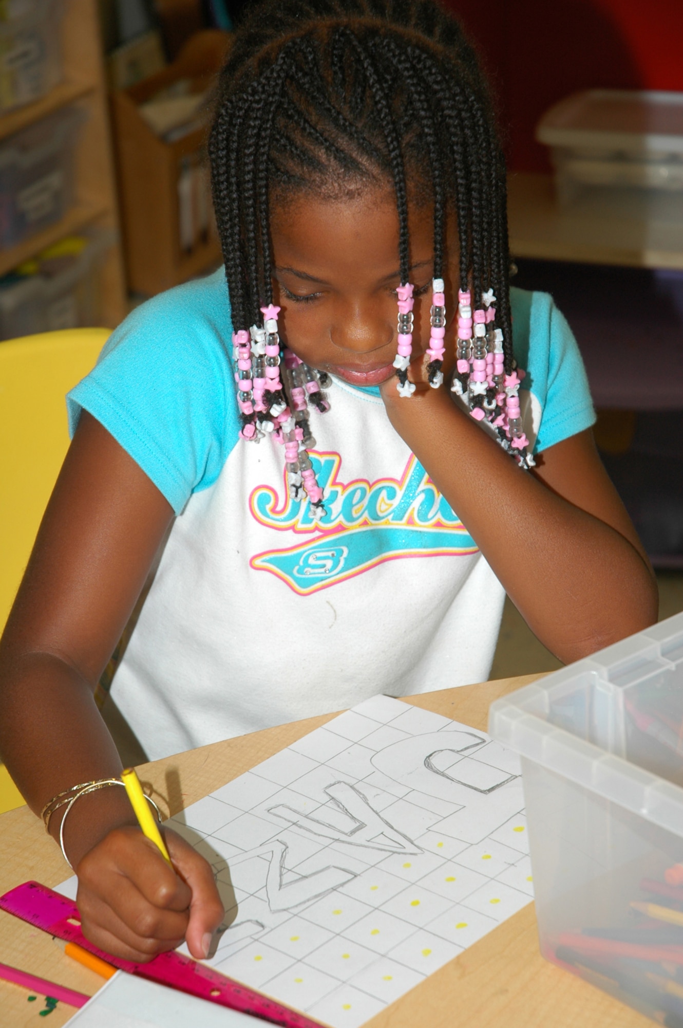 Jazmine Bell, Tyndall Elementary School fourth-grade student, takes a moment to creatively draw her name at the Youth Center's summer program where she spends her days before school starts Aug. 20. (U.S. Air Force photo by Staff Sgt. Vesta Anderson)