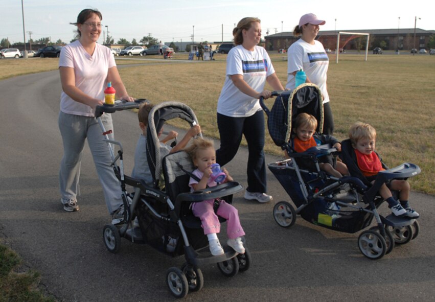 MINOT AIR FORCE BASE, N.D. -- Military spouses and their children participate in a "HAWC Walk" sponsored by the Health and Wellness Center here. The event was part of Community Cares part, which runs through Aug 31, and featured awards and prizes. Community cares month focuses on supporting families of deployed Airmen. (U.S. Air Force photo by Airman 1st Class Cassandra Jones)