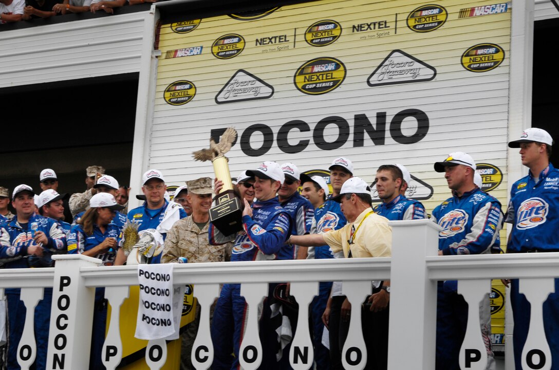 Marine Gen. Peter Pace, chairman of the Joint Chiefs of Staff (center) , looks on as Kurt Busch lifts the trophy over his head after winning the NASCAR Pennsylvania 500 auto race at the Pocono Raceway in Long Pond, Penn., Aug. 5, 2007.