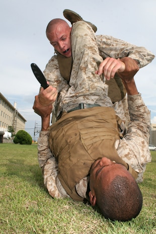 Cpls. Ryan J. Giberson (top), Marine Aviation Logistics Squadron 12 aviation supply clerk and Decatur, Ill., native, and Harold S. Brice, Headquarters and Headquarters Squadron correctional specialist and native of Preston, Md., struggle for a plastic bayonet during the Marine Corps Martial Arts Program green belt instructor course at the North Side obstacle course Aug. 7.