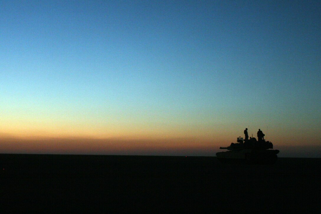 COMBAT OUTPOST RAWAH, IRAQ – The sun sets in the western Euphrates River valley as a tank sits in an over watch position. Company B, 1st Tank Battalion, which has been providing support for First Light Armored Reconnaissance Battalion, Regimental Combat Team 2, since the start of their deployment in March. Official Marine Corps Photo By Cpl. Ryan C. Heiser.
