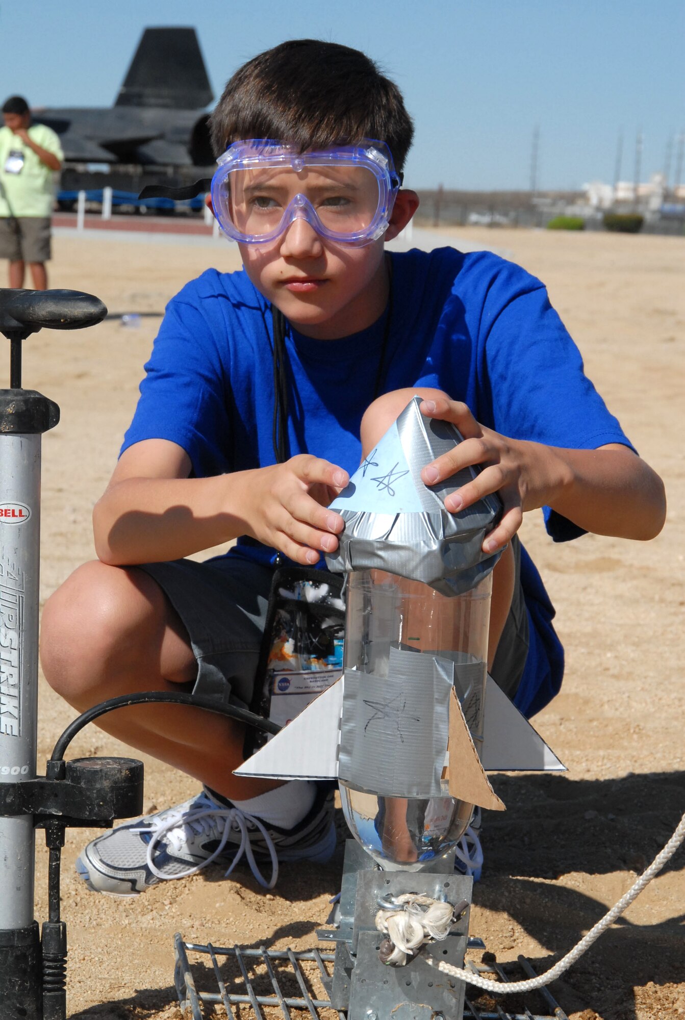 Kenton Hoshino, an 11-year-old camp participant, prepares his bottle rocket made of household items during the rocket launch activity at the NASA Dryden bottle rocket launch pad Aug. 3. The rocket launch was just one of many activities the campers participated in throughout the week. (Photo by Airman 1st Class Mike Young)