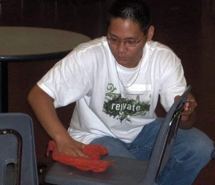 Senior Airman Joseph Devera cleans a chair at a homeless shelter in Minneapolis, Minn., during a "Week of Hope" July 7 to 14. The program is a mission trip for junior and senior high school students to provide help to needy people. Airman Devera was a leader in a "crew" of five people comprised of volunteer high school students from the Catholic and Protestant parishes at Malmstrom Air Force Base. The 20 volunteers from Malmstrom clocked 560 hours at 25 seperate worksites in the Twin Cities. The youth group plans to go to either Peru or Puerto Rico next year. (U.S. Air Force photo).