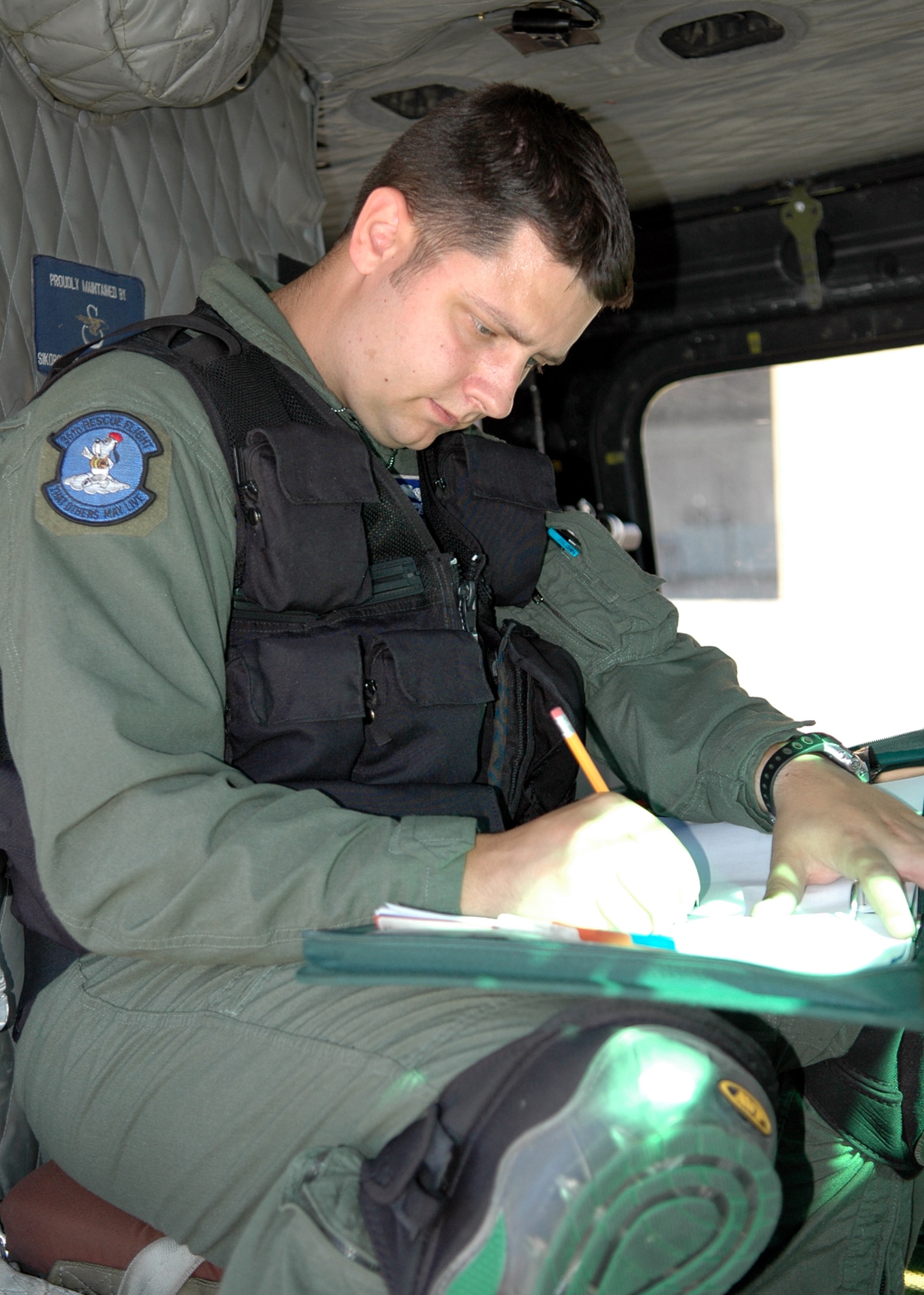 FAIRCHILD AIR FORCE BASE, Wash. -- After a successful training mission, Staff. Sgt. Jamie Aulbach, 36th Rescue Flight UH-1N Huey flight engineer, fills out post-flight paperwork inside the back of the helicopter. Post-flight actions include filling out discrepancy forms, annotating how much each pilot flew and signing off equipment like the forest-penetrating device and the survival kits. (U.S. Air Force Photo / Tech. Sgt. Larry W. Carpenter Jr.) 