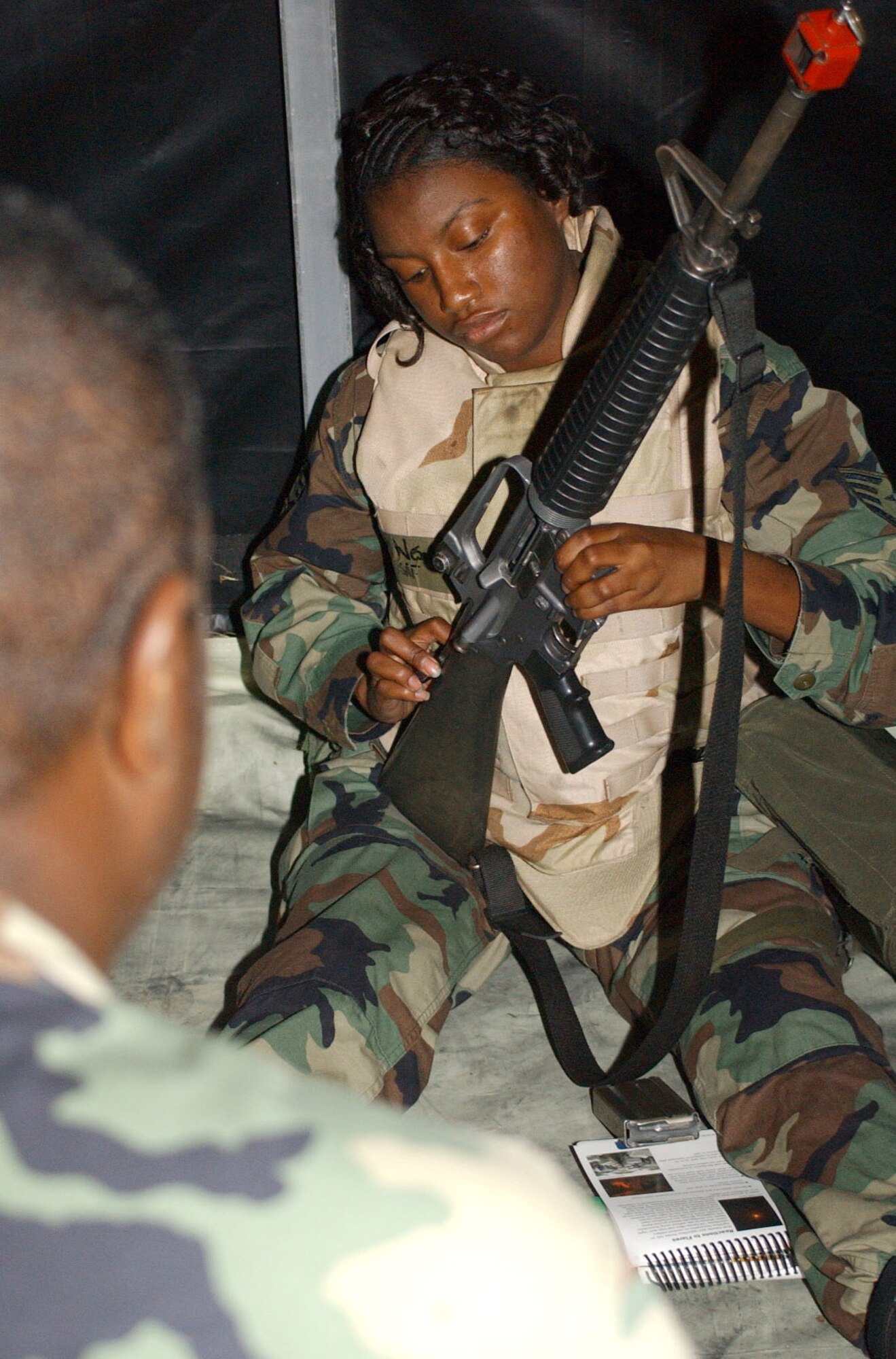 Staff Sgt. Phillip Belle, left, 81st Security Forces Squadron, instructs Staff Sgt. Lashundra Nesmith, legal office, on the proper handling of an M-16 during the contingency exercise.  (U.S. Air Force photo by Kemberly Groue)