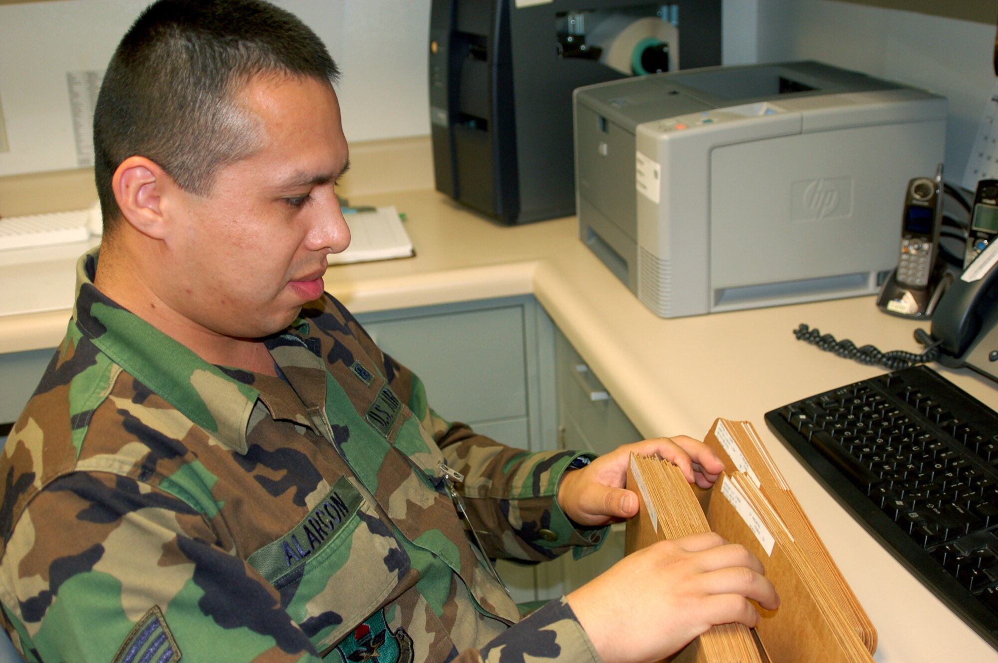 Airman Alarcon reviews genetics test folders.  (U.S. Air Force photo by Steve Pivnick)