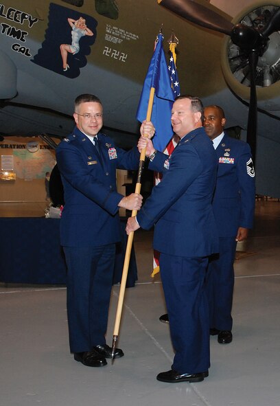 Col. Randal L. Bright, 512th Airlift Wing Commander, passes the 512th Maintenance Group guidon to Col. Alan H. Lerner in an assumption of command ceremony at the Air Mobility Command Museum August 4.  Col. Willie W. Cooper II relinquishes command of the 512th MXG as he becomes the commander of the 440th Maintenance Group at Pope AFB, N.C.  (U.S. Air Force photo/Staff Sgt. Steve Lewis)

