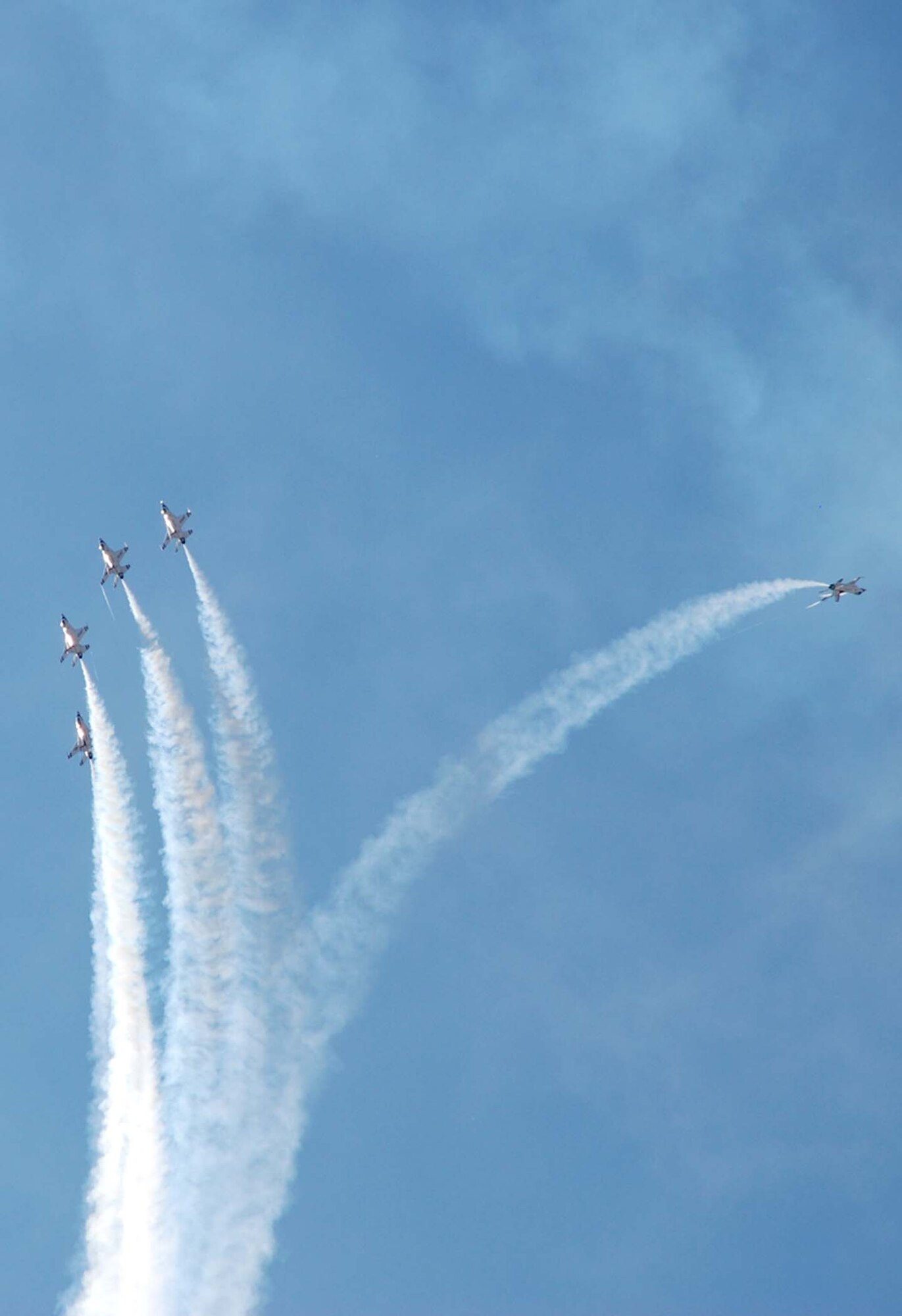 Five Thunderbirds perform an overhead roll as one of the aircraft separates from the group (Photo by Staff Sgt. Chad Thompson).