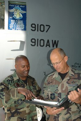 YOUNGSTOWN AIR RESERVE STATION, Ohio - Air Force Reserve Master Sgt. Michael J. Klodt, crew chief of the 910th Airlift Wing's aircraft 9107, reviews a maintenance log book with his assistant crew chief, Tech. Sgt. Less Parkey. Master Sgt. Klodt has been the crew chief on 9107 since it arrived here from the factory in 1991. His review of the log with Tech Sgt. Parkey was one of his last official duties as crew chief prior to his retirement July 5 after 36 years of service to the Air Force. U.S. Air Force photo/Tech. Sgt. Bob Barko Jr.