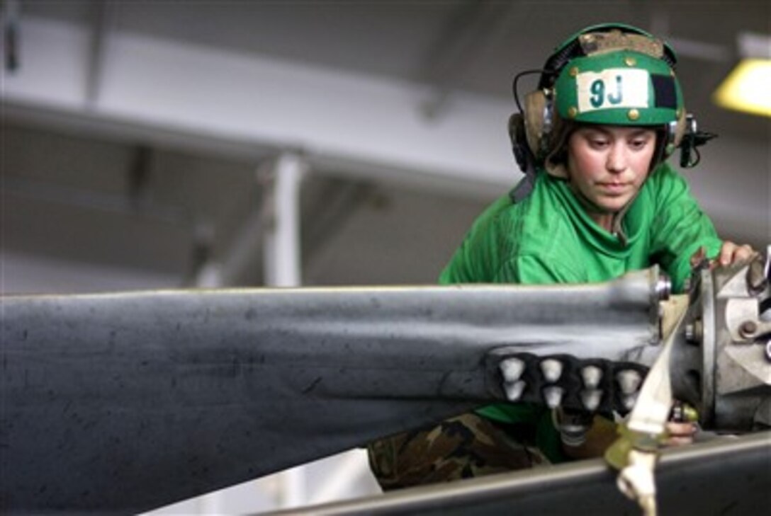 U.S. Navy Petty Officer 1st Class Sara Paulk loosens bolts to remove a rotor blade from an HH-60H Pave Hawk helicopter in the hangar bay of the aircraft carrier USS Kitty Hawk's while at sea,  Aug. 5, 2007. Paulk is a Navy aviation machinist's mate. 