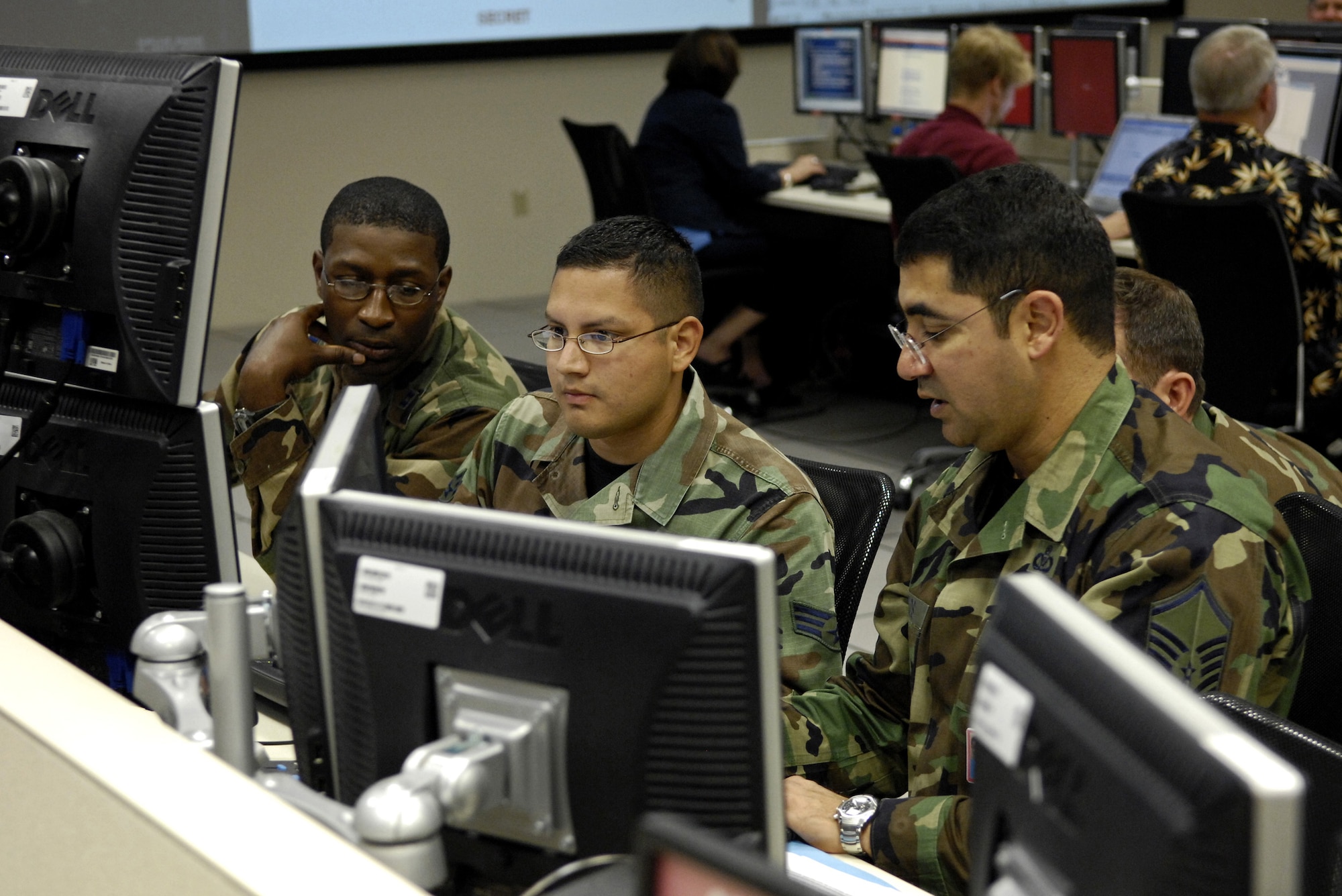 HICKAM AIR FORCE BASE, Hawaii -- Members of the personnel recovery coordination cell discuss a downed pilot recovery mission Aug. 7 in the air operation center here, Hawaii during Exercise Valiant Shield. The Airmen are from the 613th Air Operations Center. Valiant Shield is a week-long exercise, which tests the military’s ability to rapidly consolidate joint forces in response to regional contingencies, involves approximately 22,000 troops, 30 ships and some 275 aircraft. (U.S. Air Force photo/Tech. Sgt. Shane A. Cuomo) 