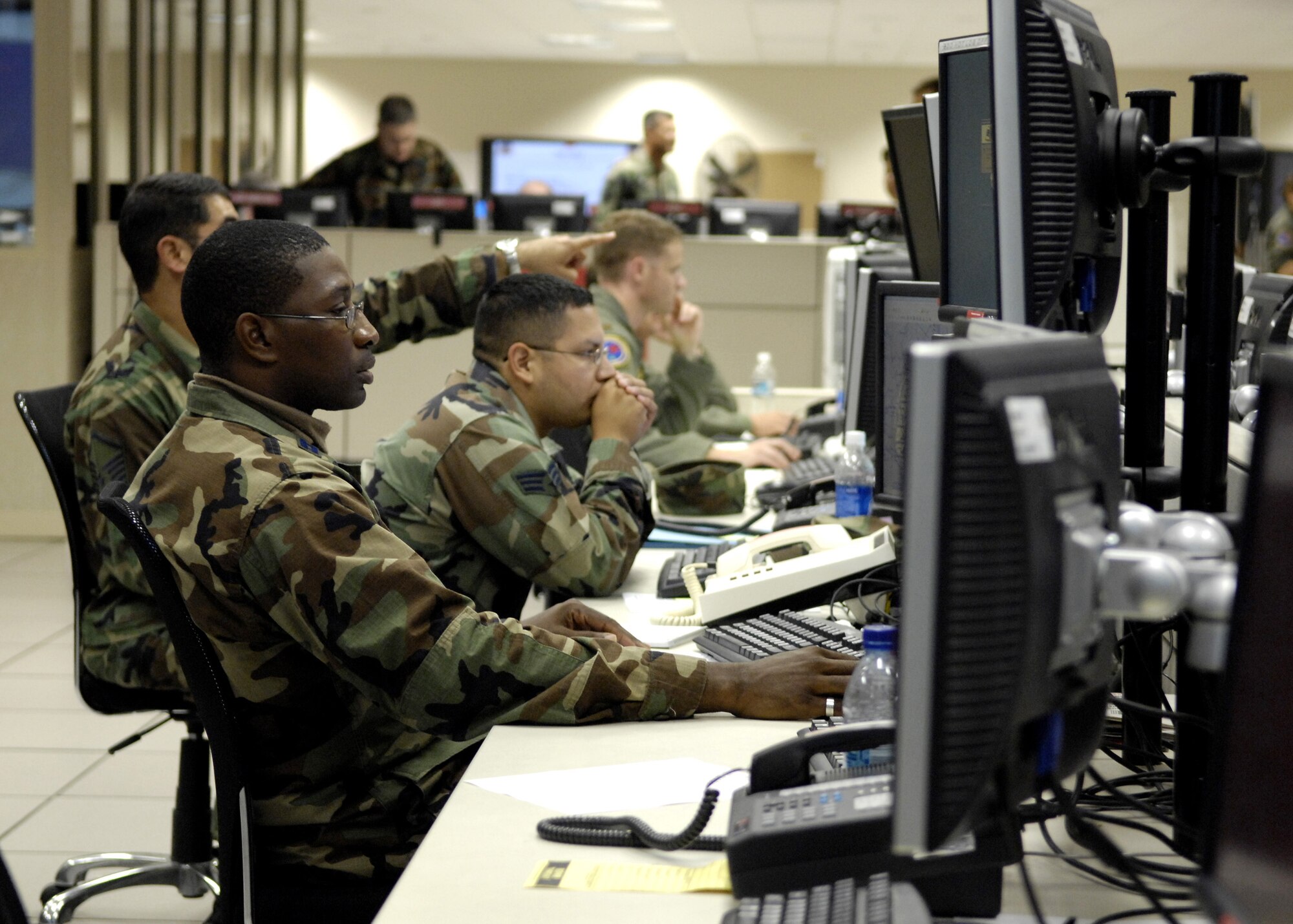 HICKAM AIR FORCE BASE, Hawaii -- Members of the personnel recovery coordination cell discuss a downed pilot recovery mission Aug. 7 in the air operation center here during Exercise Valiant Shield. The Airmen are from the 613th Air Operations Center. Valiant Shield is a week-long exercise, which tests the military’s ability to rapidly consolidate joint forces in response to regional contingencies, involves approximately 22,000 troops, 30 ships and some 275 aircraft. (U.S. Air Force photo/Tech. Sgt. Shane A. Cuomo) 