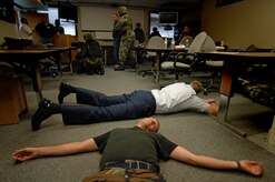 Staff Sgt. Louis Wall, 437th Civil Engineer Squadron emergency management apprentice, plays dead during an exercise as others wait as hostages in the 437th Civil Engineer Squadron readiness flight building on base Aug. 1. Team Charleston participated in a base-wide exercise that simulated an emergency scenario similar to what happened at Virginia Tech. (U.S. Air Force photo/Airman 1st Class Nicholas Pilch) 