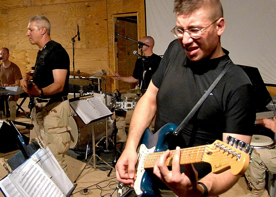 Senior Airman Andrew Minns, lead guitarist for the U.S. Central Command Air Forces Band "Live Round," displays his game face during a show July 19 at Kirkuk Air Base, Iraq. Kirkuk is a key element in the coalition effort of the reconstruction of Iraq. The band is currently on a 60-day deployment performing throughout Iraq and Afghanistan. (U.S. Air Force photo/Chief Master Sgt. John A. Zincone)