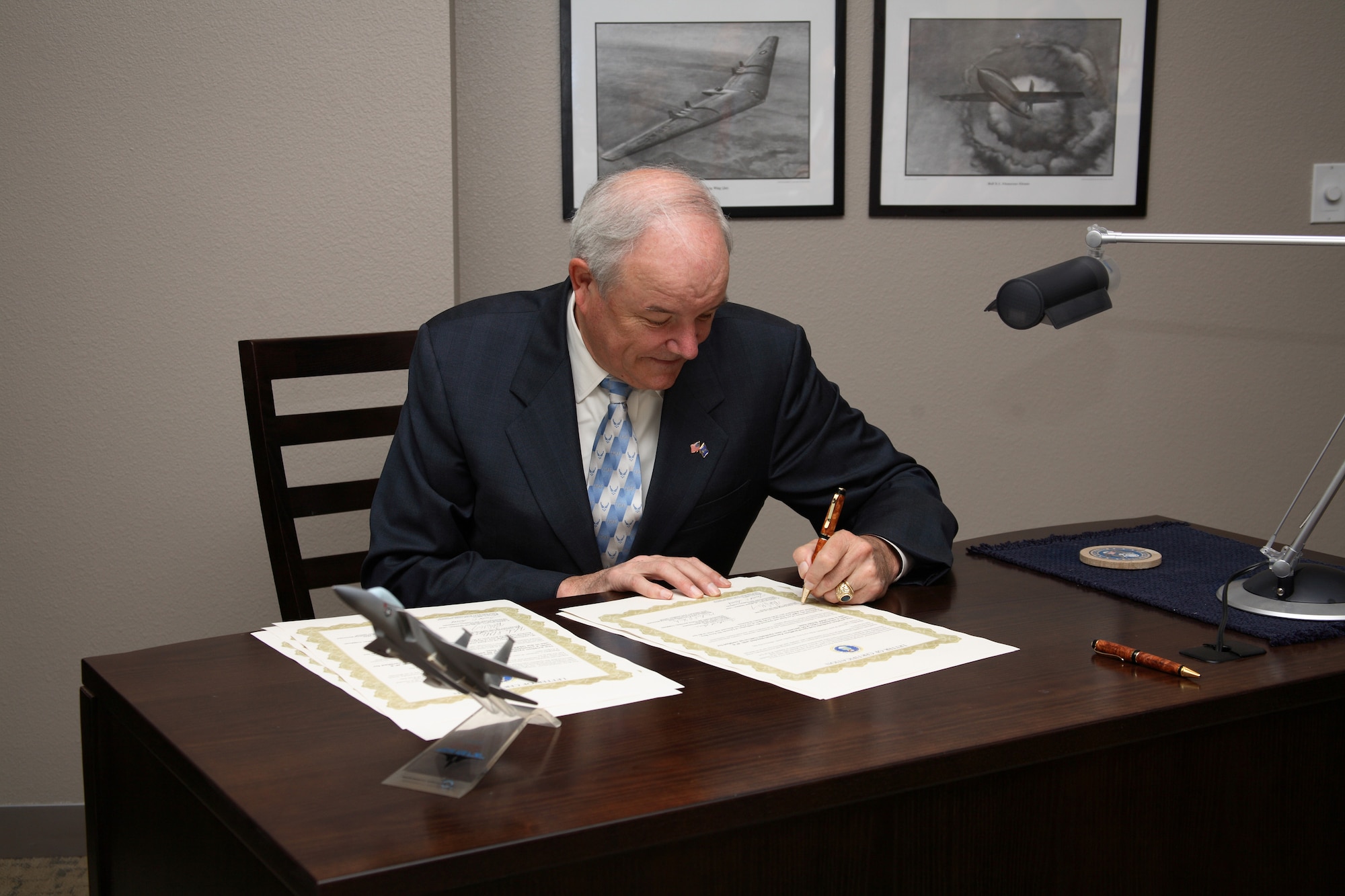 EDWARDS AIR FORCE BASE, Calif. -- Secretary of the Air Force Michael W. Wynne signs several copies of a document here Aug. 8, certifying Fischer-Tropsch synthetic fuel blends for use in the B-52H. (Photo by Jet Fabara)