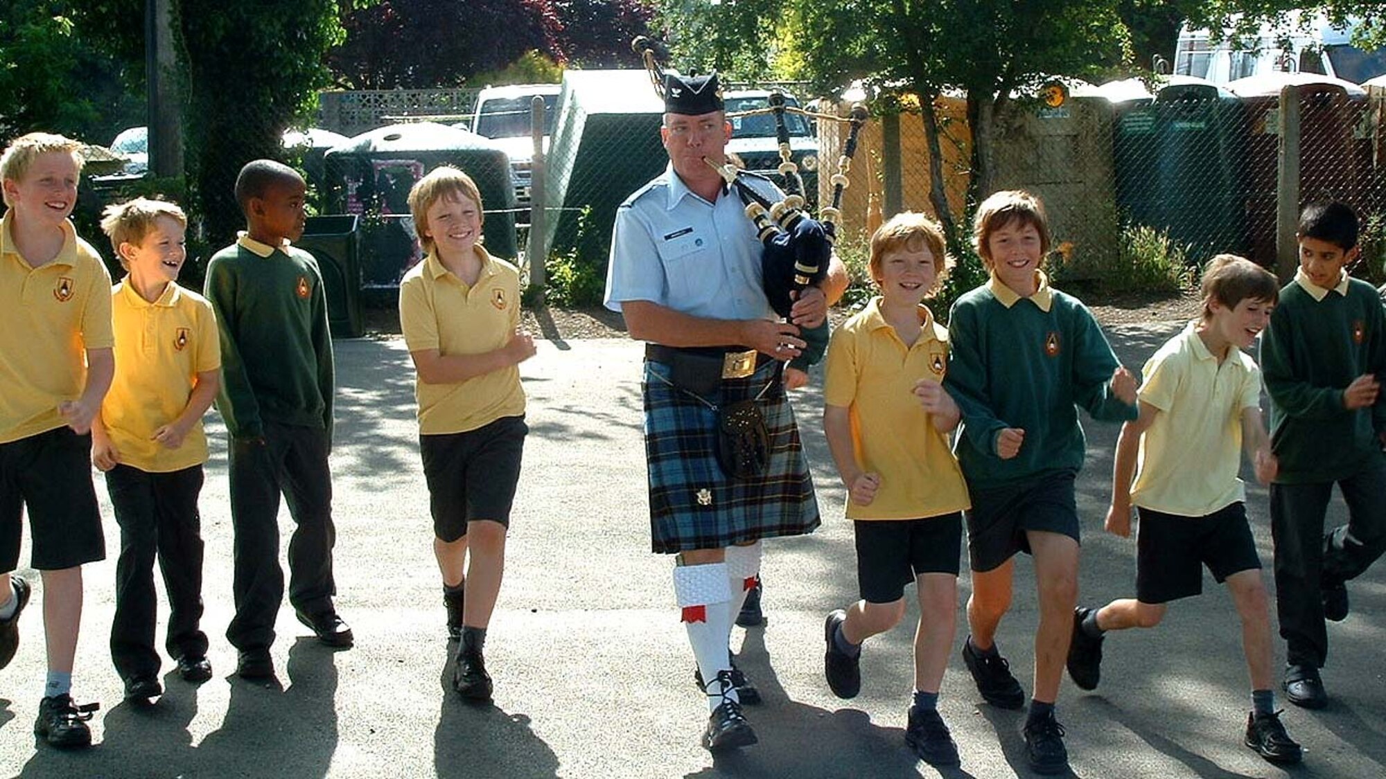 FAIRFORD, United Kingdom -- Col. William McKinley, a Reservist augmenting the U.S. Air Force Reserve Pipe Band, marches a group of school children from the Kempford School here back to class following one of seven school performances the band did during their two-week trip to the United Kingdom as part of the Air Force 60th Anniversary Celebration. (U.S. Air Force photo/Staff Sgt. Eric Frank)