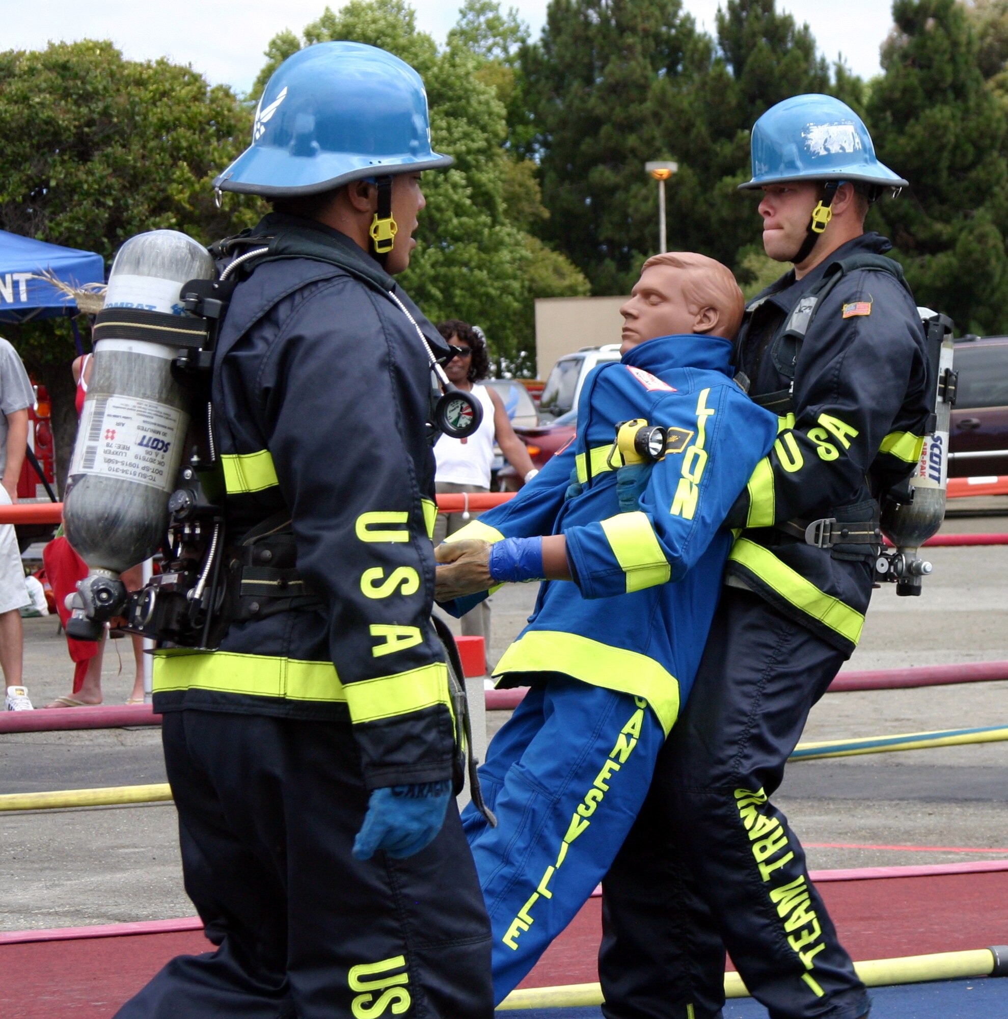 Aldrico Caragan, Travis firefighter, motivates teammate, Senior Airman Kenny Setty, during the team relay event at the Scott Firefighter Combat Challenge in Fremont, Calif., Aug. 5. (U.S. Air Force photo/Karen Caragan)