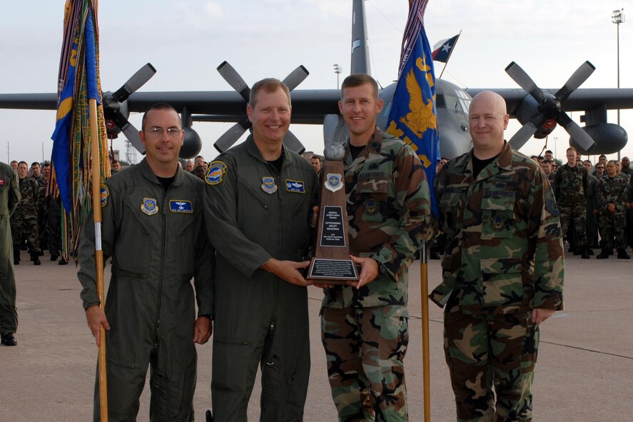 DYESS AIR FORCE BASE, Texas -- Lieutenant Colonels Mike Zick and David Wiesner, together with Master Sergeants David Wells and Jarrod Sebastian, all 40th Airlift Squadron, accept the Lt. Gen. Joseph Smith trophy Aug. 3 for the most outstanding Airlift Squadron in Air Mobility Command. (U.S. Air Force photo by Senior Airman Courtney Garrard)   