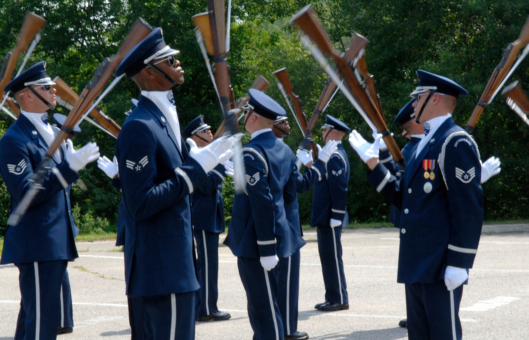 HANSCOM AFB, Mass. -- The Air Force Honor Guard Drill Team performs in Minute Man National Historical Park in Lexington, Mass. Aug. 7. The Drill Team conducted two, 20-minute performances during their visit to Hanscom AFB. On Aug. 6 the Drill Team performed on base for the base populace; on Aug. 7 the Drill Team performed for the public in the park. Both shows featured precise weapons tosses and maneuvers as well as complex weapon exchanges. (U.S. Air Force photo by Jan Abate)
