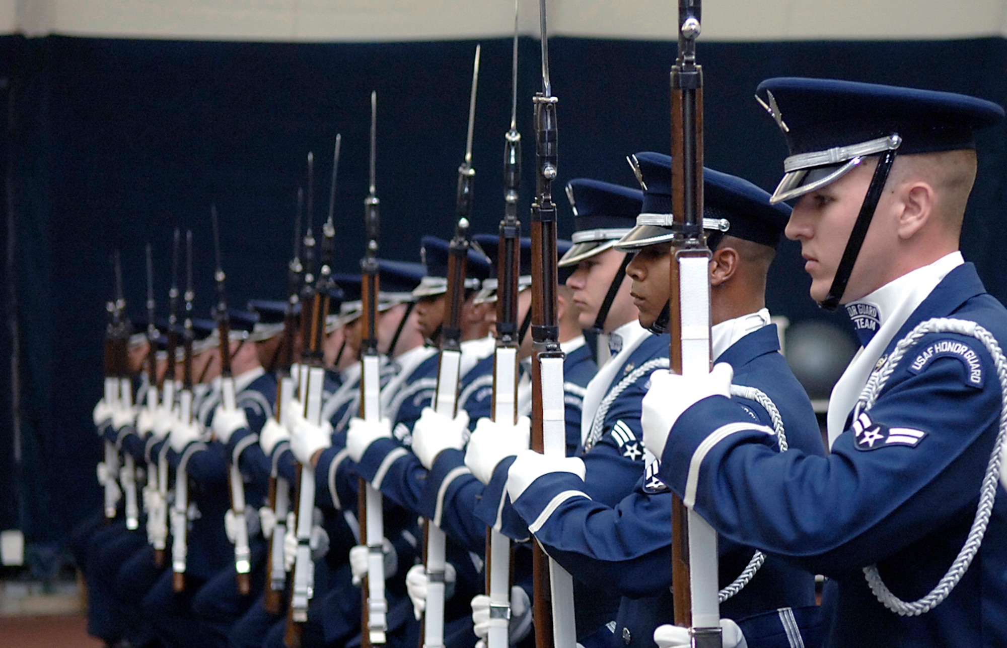 HANSCOM AFB, Mass. -- The Air Force Honor Guard Drill Team performs in the Hanscom AFB Tennis Bubble before an audience of base personnel and their families Aug. 6. The team performed before a general public audience the next day, Aug. 7, in Minute Man National Historical Park in Lexington, Mass. The two, 20-minute shows featured precise weapons tosses and maneuvers as well as complex weapon exchanges. (U.S. Air Force photo by Jan Abate)