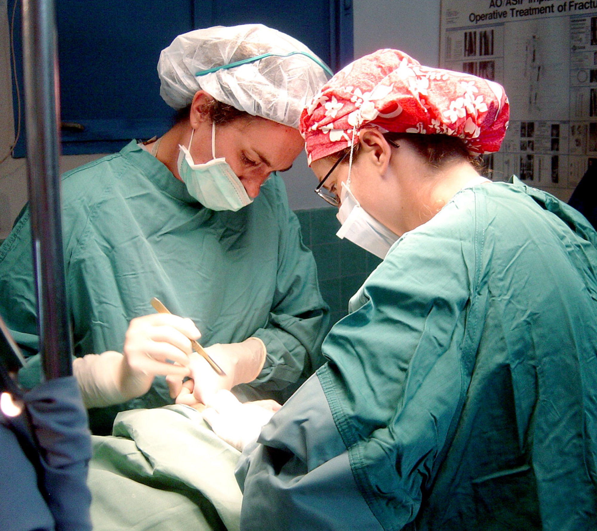 Navy Cmdr. (Dr.) Amy O'Boyle and Navy Lt. Jennifer Ftiscar perform surgery on a local woman July 25 at Espiritu Santo hospital in Vanuatu. Commander O'Boyle is a an obstetrics/gynecological surgeon, and Lieutenant Ftiscar is an OB/GYN resident, both from Naval Medical Center Portmouth, Va. They were part of an OB/GYN surgical team that visited Espiritu Santo island in the nation of Vanuatu to train medical staff and perform surgery. The team was part of the Oceania Humanitarian Assistance Mission that brought medical, dental and engineering servicemembers to perform civil assistance projects on Vanuatu, Nauru and Kiribati July 20 through 30. (U.S. Air Force photo) 
