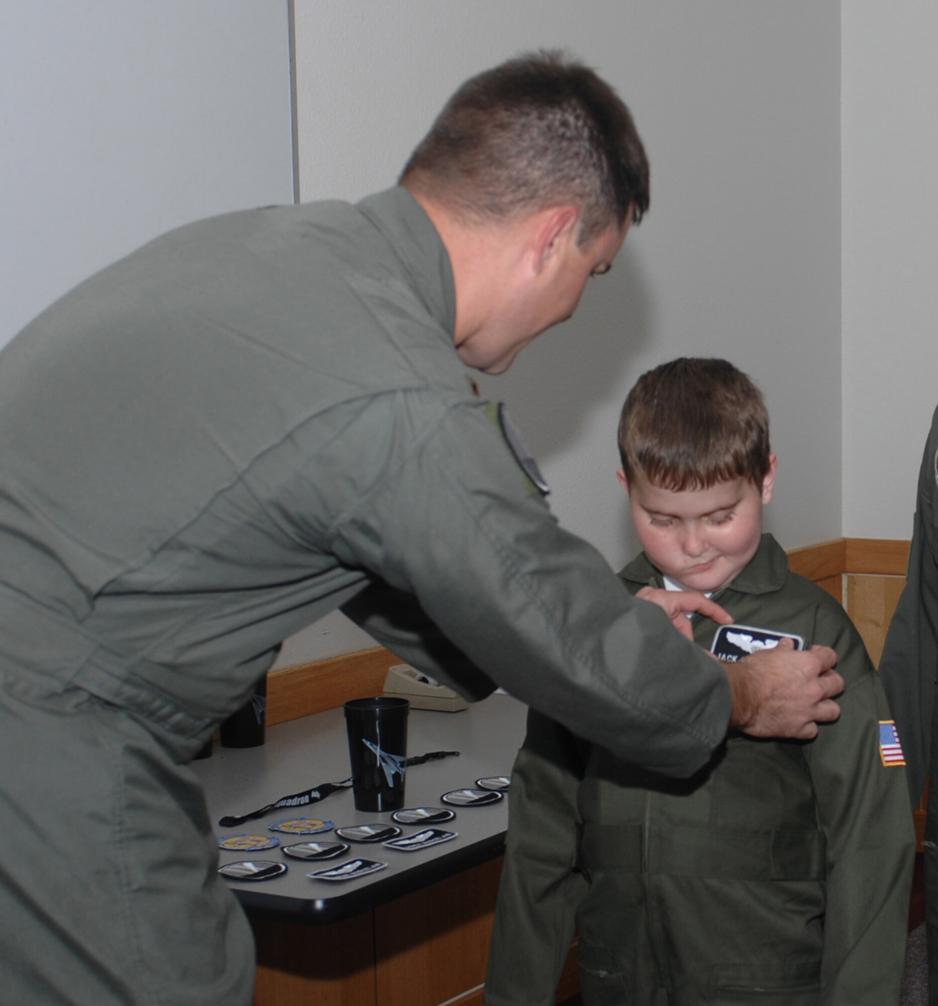 Jack Marcelain receives his nametape for his flight suit by Maj. Dave Henshaw, his pilot escort for the day. As part of the Pilot For a Day program, Jack received a flight suit and other gifts from the 9th Bomb Squadron.