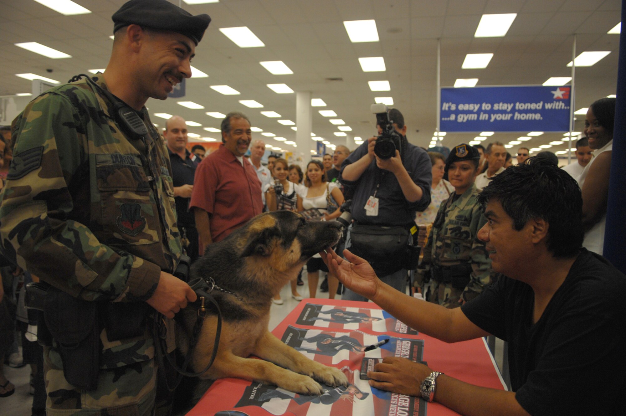 Staff Sergeant Benjamin Dunton, 99th Security Force Squadron, dog handler, and Ricki, K-9 guard dog meet Comedian George Lopez at a Meet and Greet session at the Nellis Air Force Base Exchange August 4, 2007. Mr. Lopez visited Nellis AFB, NV while in Las Vegas to perform for his America’s Mexican Tour at the Las Vegas Hilton Hotel. 
(U.S. Photo by Airman 1st Class Nadine Y. Barclay)(RELEASED)
