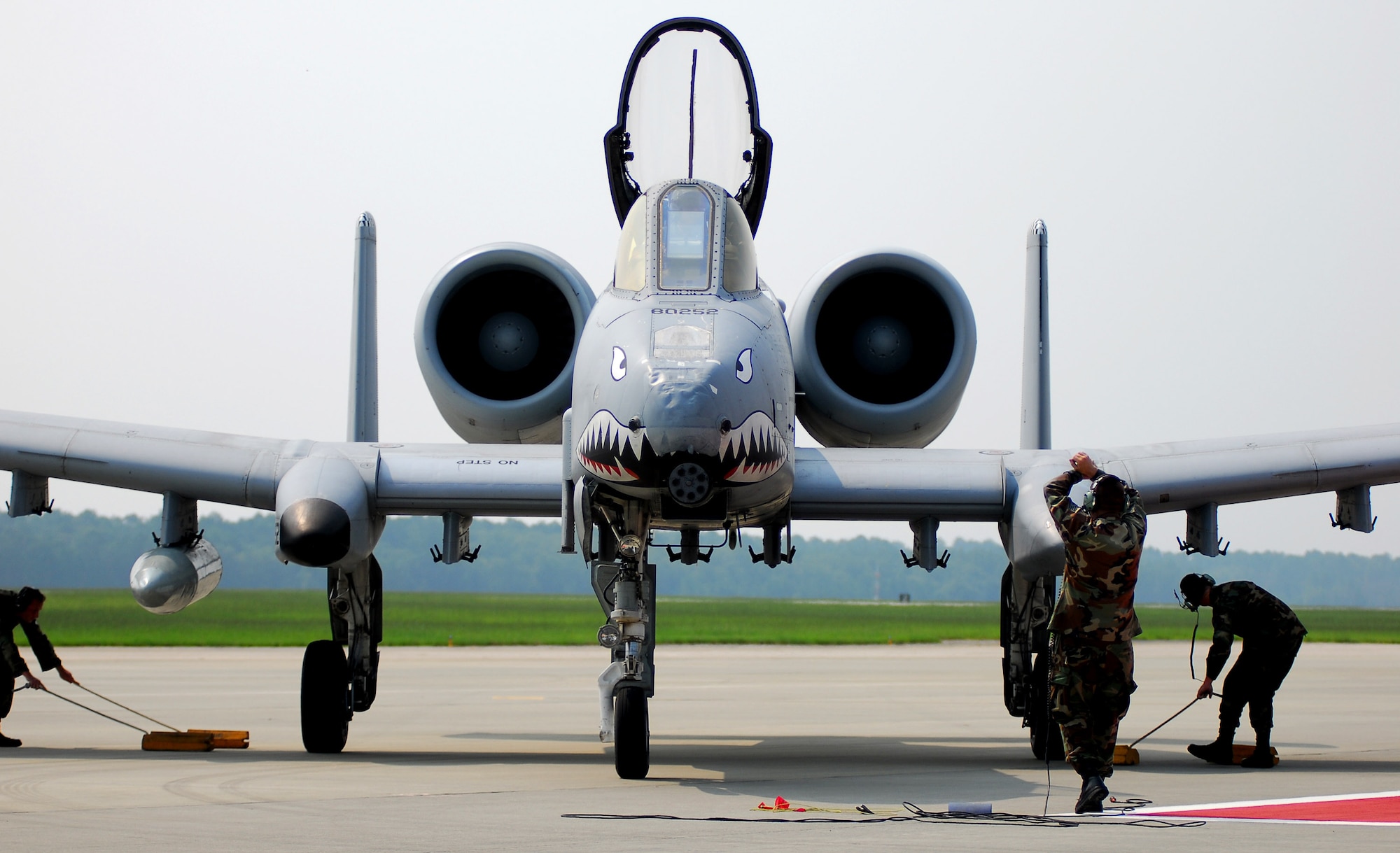 Maintainers with the 23rd Maintenance Group place the chocks under the first A-10C Thunderbolt II Aug. 7 at Moody Air Force Base, Ga. This aircraft is the first of approximately 50 upgraded A-10Cs moving to the base as a part of a force realignment. The move is expected to be complete in early spring 2008. The upgrades enable the A-10C to deliver the Air Force's latest generation of precision guided munitions and improve the A-10's communications capabilities, allowing the aircraft to share detailed information with ground-based warfighters. (U.S. Air Force photo/Tech. Sgt. Parker Gyokeres) 
