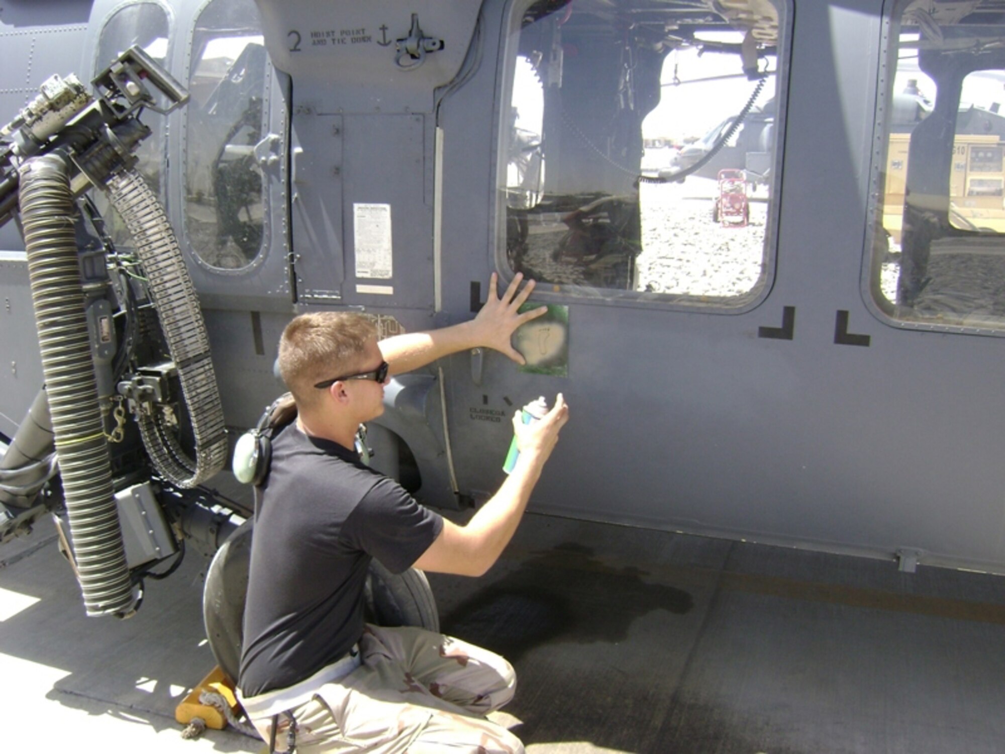 Airman 1st Class Addison Reibling paints a beige foot onto an 33rd Rescue Squadron HH-60 Pave Hawk after the unit's first rescue of the deployment at the beginning of August.  The squadron carried an Afghan national criticallywounded by an improvised explosive devise to a combat hospital for emergency surgery.   The 33rd RQS from Kadena Air Base, Japan, deployed the end of July to Kandahar to conduct combat search and rescue and medical rescue missions in support of Operation Enduring Freedom. The squadron headed back to Afghanistan after returning from a four-month deployment to Kandahar in May.  Airman Reibeling is a crew chief with 718th Aircraft Maintenance Squadron.  U.S. Air Force photo