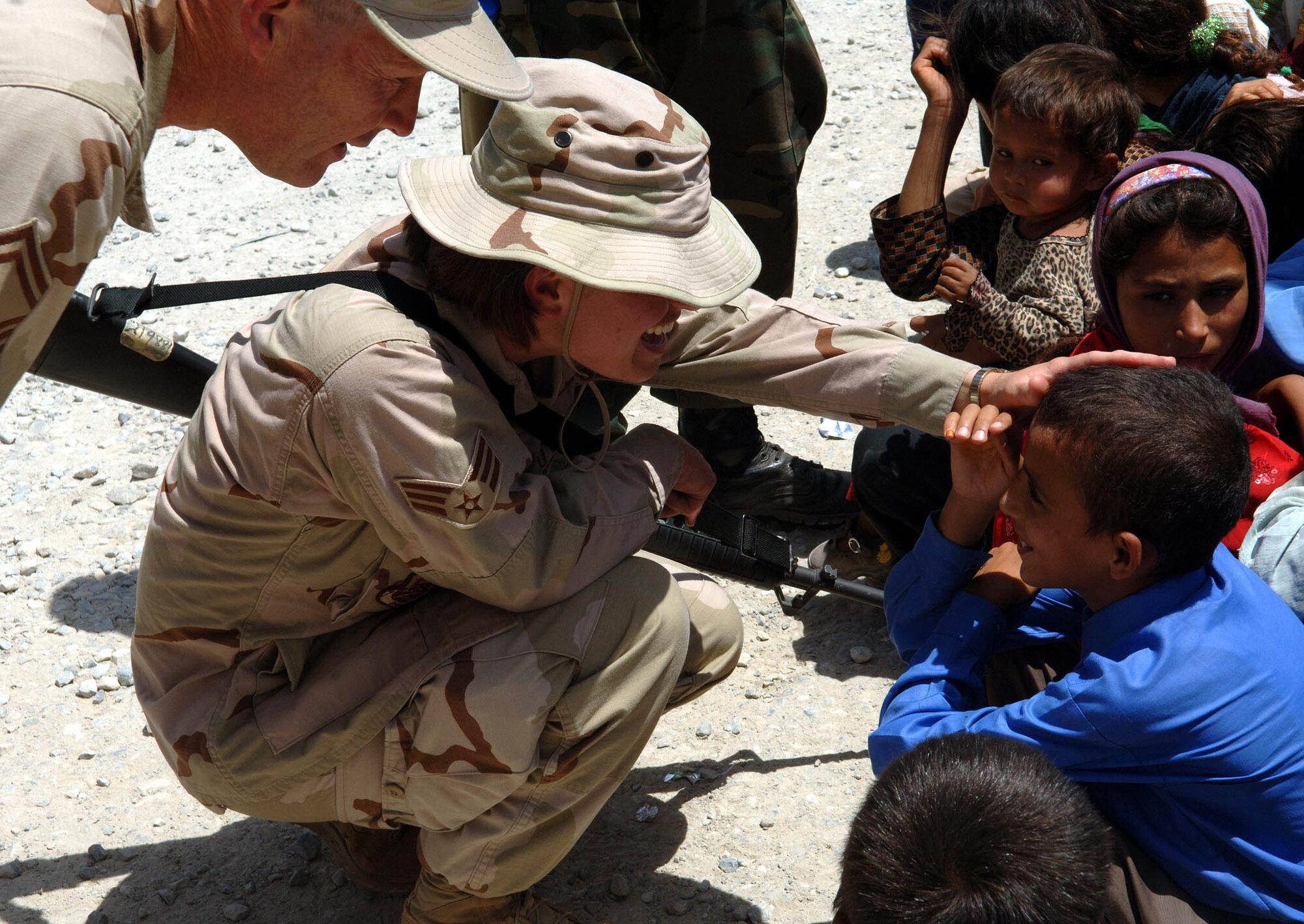 BAGRAM AIRFIELD, Afghanistan - Airmen from Task Force Med meet and play with children at the Egyptian compound Aug. 7 at Bagram Airfield, Afghanistan. TF Med Airmen also distributed humanitarian aid packages filled with toys and school supplies to the women and children in the compound. (U.S. Air Force photo by Staff Sgt. Craig Seals)