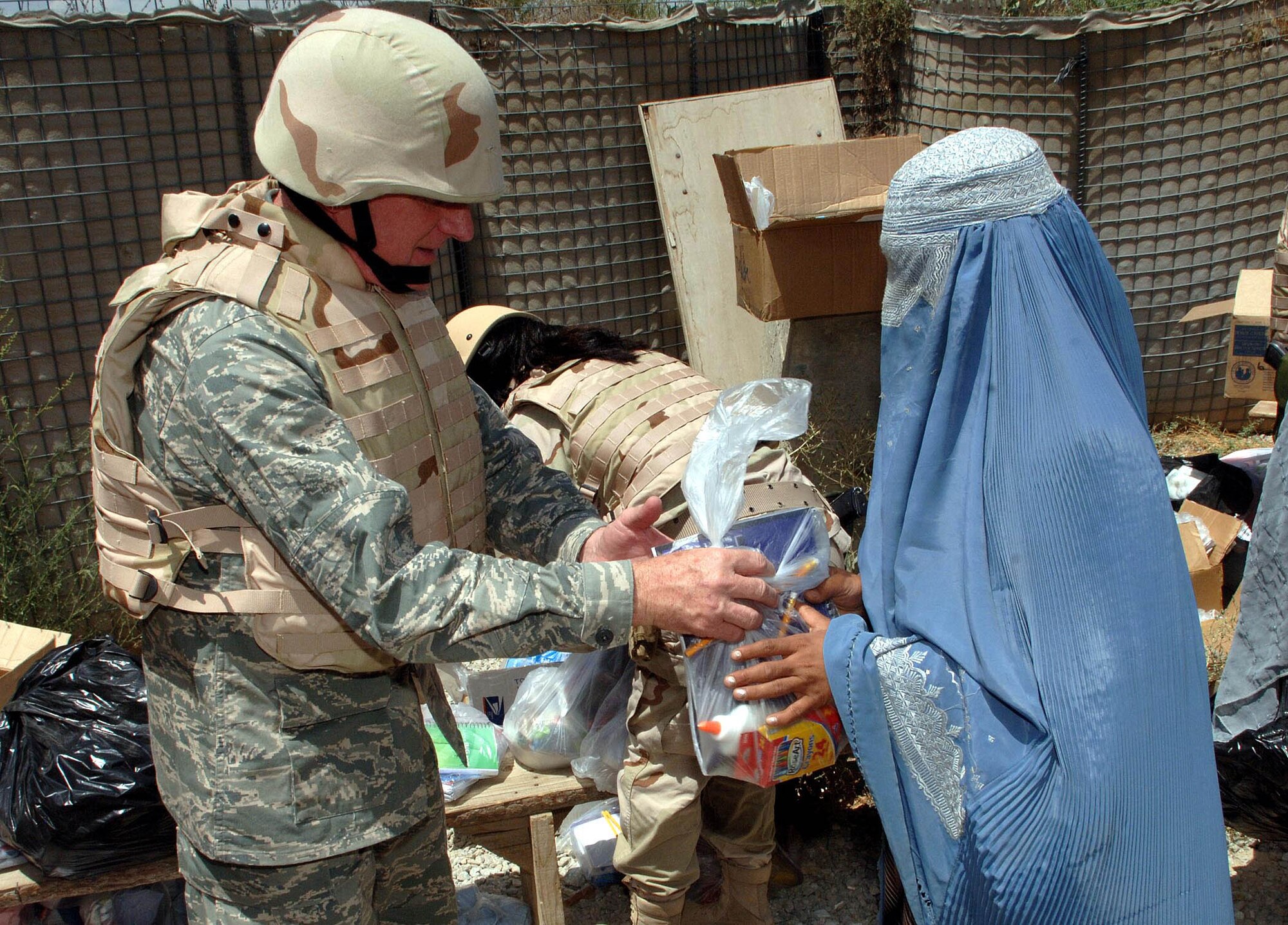 BAGRAM AIRFIELD, Afghanistan - Chaplain (Maj. Gen.) Charles Baldwin, Air Force chief of chaplains, hands out humanitarian aid packages to women and children in the Egyptian compound Aug. 7 at Bagram Airfield, Afghanistan. Chaplain Baldwin met with 455th Air Expeditionary Wing leadership, as well as coalition leadership, during his tour of Bagram spreading the goodwill and well wishes of the Air Force to the many servicemembers and nations stationed here. (U.S. Air Force photo by Staff Sgt. Craig Seals)