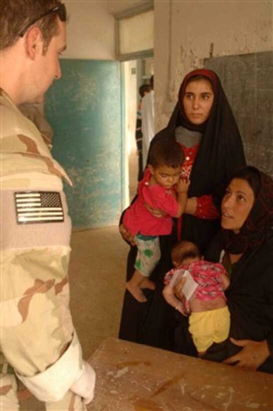An Iraqi mother discusses the condition of her child with a soldier from the U.S. Army Special Forces in Juhaysh, Iraq, Aug. 4, 2007.  Special Forces soldiers are visiting a village just outside their compound to distribute humanitarian assistance and medical aid.  