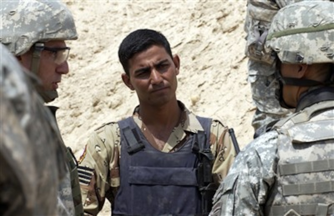 U.S. Army Lt. Col. Viet Luong, commander of 2nd Panther Battalion, 505th Parachute Infantry Regiment, 3rd Brigade Combat Team, 82nd Airborne Division, talks to an Iraqi army soldier, with the help of an interpreter, about the importance of a checkpoint in Samarra, Iraq, Aug. 3, 2007. 