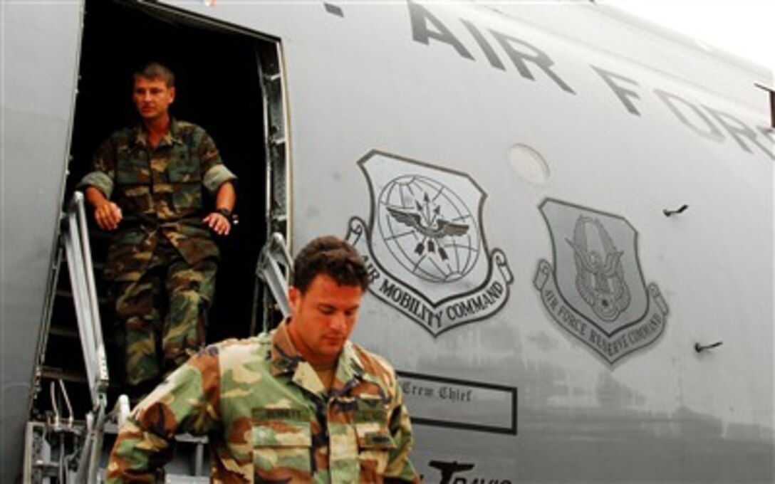 U.S. Navy divers Petty Officer 1st Class Brian Bennett, front, and Petty Officer 2nd Class Phil Hartman, both assigned to Mobile Dive and Salvage Unit 2, from Naval Amphibious Base Little Creek, Va., arrive at 934th Air Reserve Base in Minneapolis, Aug. 6, 2007. The divers will assist in recovery efforts at the site of the collapsed I-35 bridge over the Mississippi River.