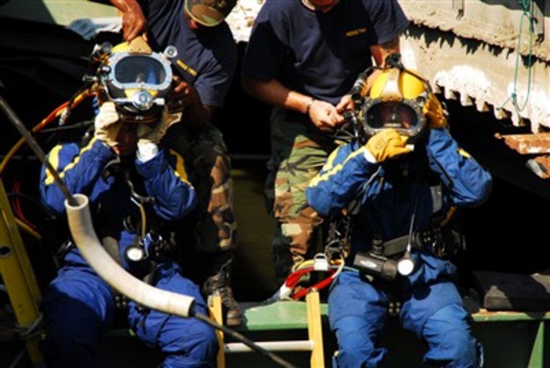 U.S. Navy divers from Mobile Diving and Salvage Unit 2, out of Naval Amphibious Base Little Creek, Va., prepare to enter the water at the site of the I-35 bridge collapse over the Mississippi River in Minneapolis,  Aug. 7, 2007.