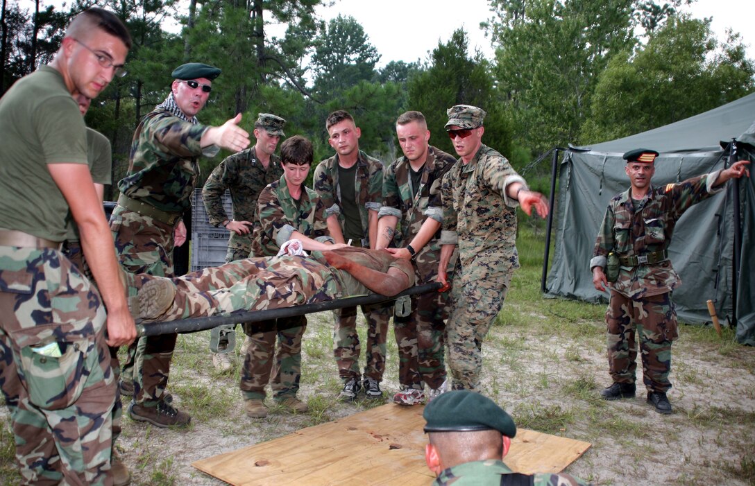?Onslovian? soldiers carry a wounded ?Onslovian? soldier after a Marine applied medical treatment during a training scenarnio. In order to assist in U.S. Marine Corps Forces, Special Operations Command?s growing Foreign Internal Defense mission requirements, H Company, 2d Marine Special Operations Battalion, completed a five-day advisor field exercise at Landing Zone Parrot, here, Aug. 5-9. With this AdFEX, and other extensive training like it, the Marines of MSOC H will be better prepared to accomplish FID missions while deployed around the globe.