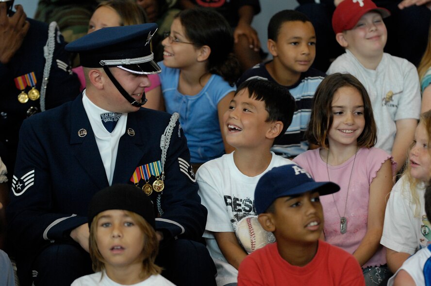 Staff Sgt. David Leininger, NCOIC of Recruiting at the Air Force Honor Guard, talks with a young boy from the Aviano Child Development Center after the team's perfomance. During their Europe tour, the Drill Team will visit five major AF installations/events in three countries to recruit, retain and inspire while promoting and representing the Air Force internationally. (U.S. Air Force photo by Senior Airman Daniel DeCook)(Released)