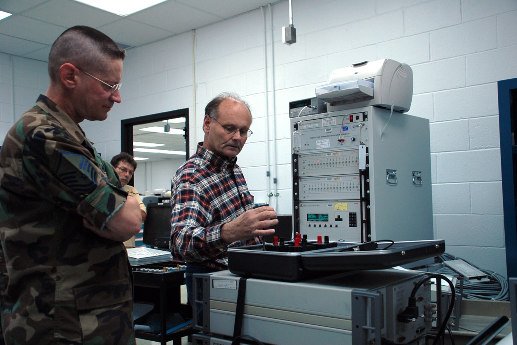 Master Sgt. Richard Jordan, 562nd Combat Sustainment Group, oversees Edward Mulford calibrating a base-reference standard. All Air Force equipment must maintain tracability to the National Institute of Standards and Technology; base-reference standards are vital in the chain of traceability because they are used as standards to calibrate Air Force test, measurement and diagnostic equipment. (U.S. Air Force photo/Tech. Sgt. Kevin Wallace)