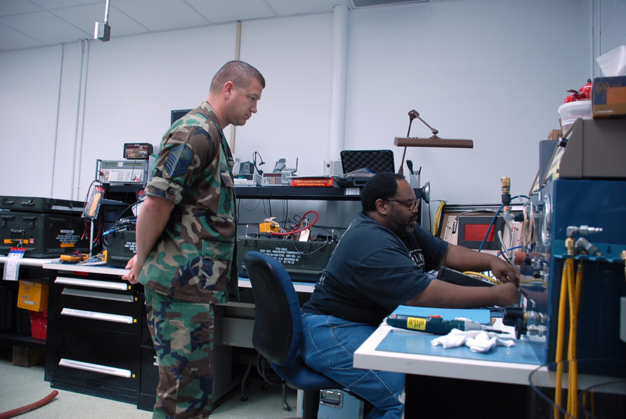 Master Sgt. Michael Sumich, 562nd Combat Sustainment Group, oversees Michael Warring’s calibration of a digital vacuum transducer as part of Dover Air Force Base’s precision measurement equipment laboratory biannual evaluation and certification. Most PMEL facilities are audited every two years to ensure their measurements and calibrations practices are ‘in tolerance.’ (U.S. Air Force photo/Tech. Sgt. Kevin Wallace)
