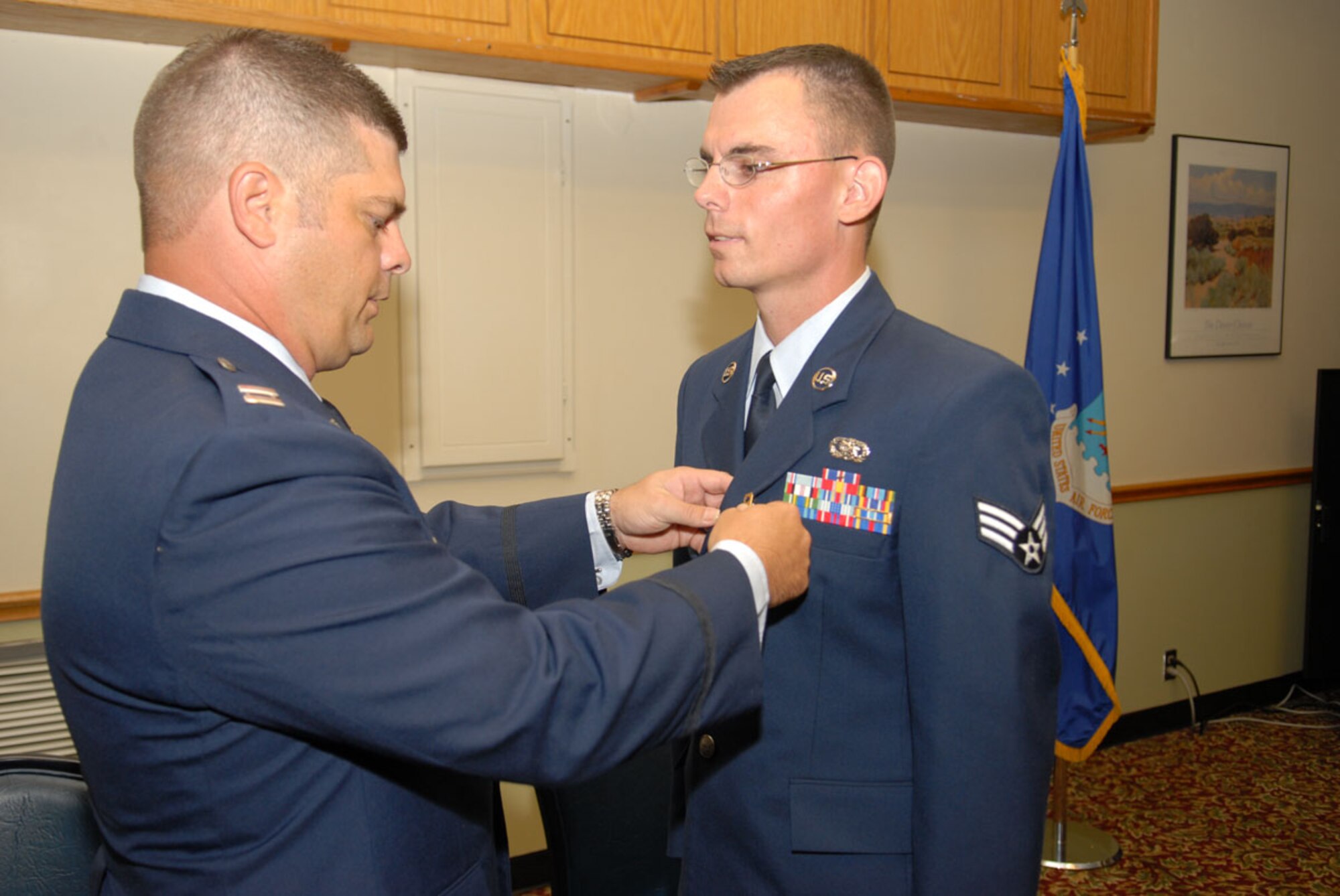 Capt. Michael Petz, 97th Communications Squadron, awards Senior Airman Brandan Eakins, 97th CS, the Purple Heart for injuries he sustained during combat while deplyed to Afghanistan. (U.S. Air Force photo/Airman 1st Class Jennifer Flores)