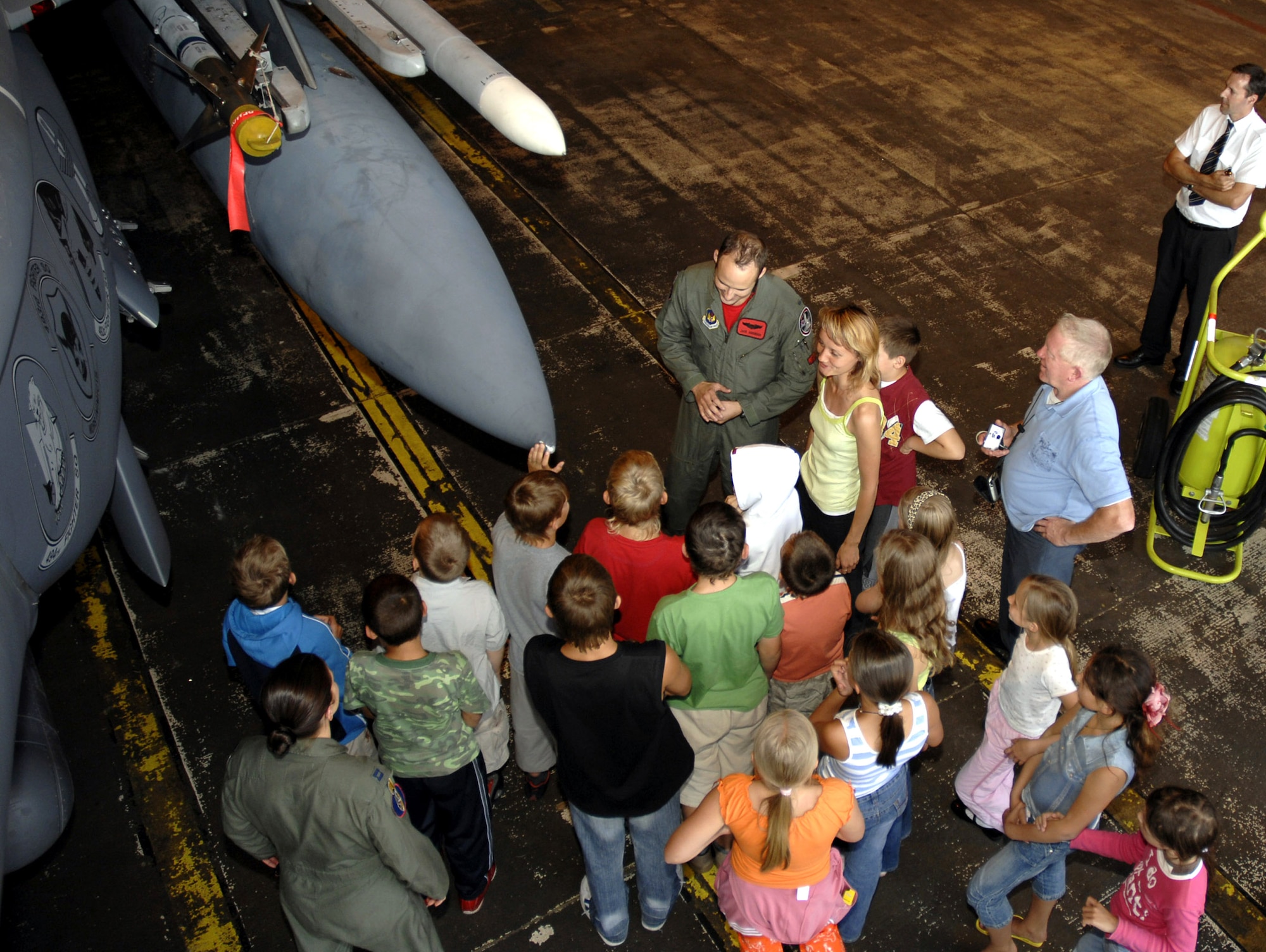 More than 20 Belarusian children huddle around 1st Lt. Jacob Anderson, a 494th Fighter Squadron pilot, as he talks about the F-15E Strike Eagle at Royal Air Force Lakenheath, England. The children got to tour the base as part of their visit to the United Kingdom through a charity called the Chernobyl Children Lifeline. The charity was founded for the children of Belarus, which is a developing country that suffered most from the fall-out caused by the Chernobyl nuclear accident in 1986. (U.S. Air Force photo/Airman 1st Class Erika Brooke)