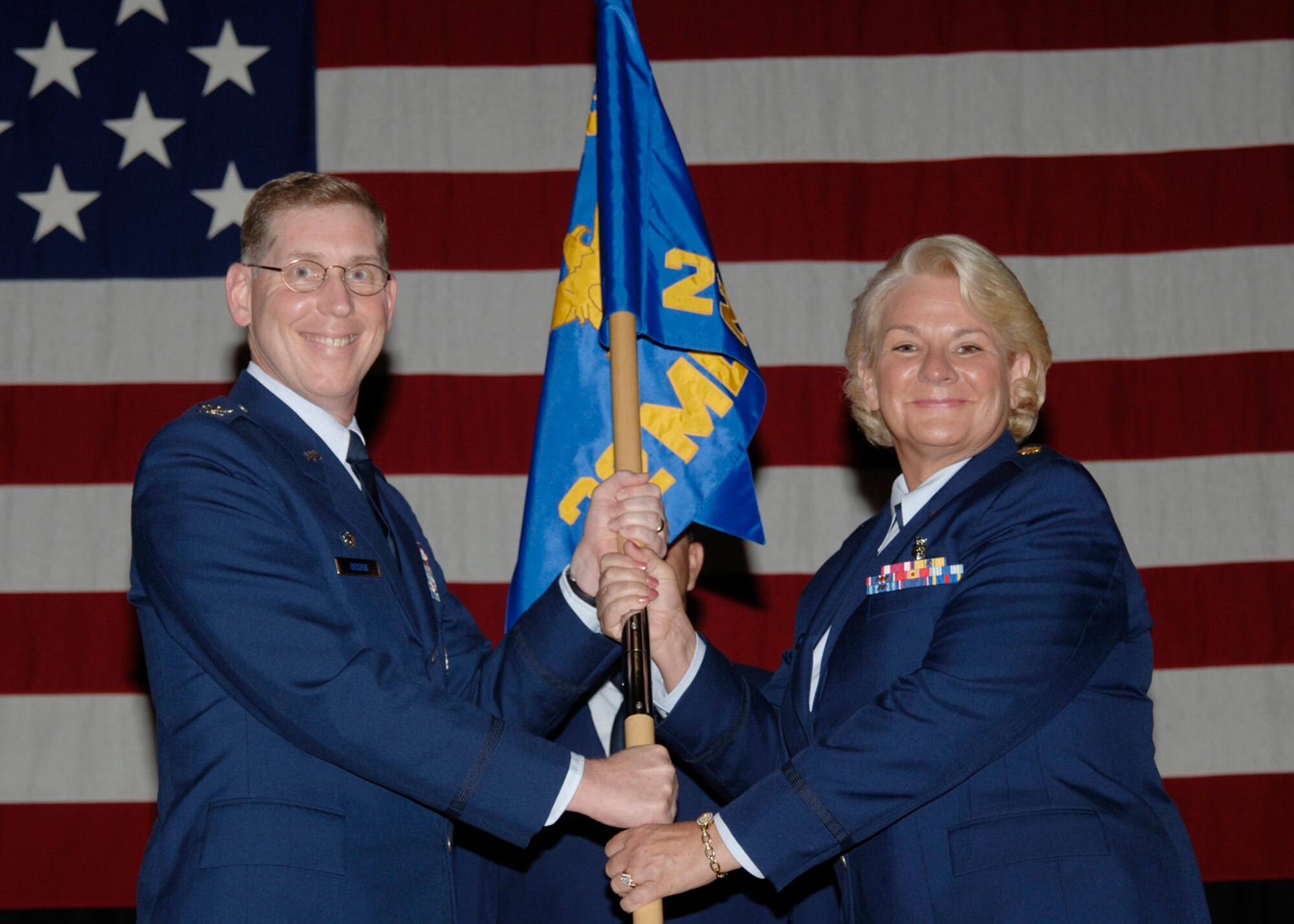 MCCONNELL AIR FORCE BASE, Kan. -- Col. Kerry Dexter, 22nd Medical Group commander, hands the 22nd Medical Operations Squadron guidon and command of the squadron to Maj. Christine Pierce Aug. 1 during a change of command ceremony here. (Photo by Airman 1st Class Jessica Corob)