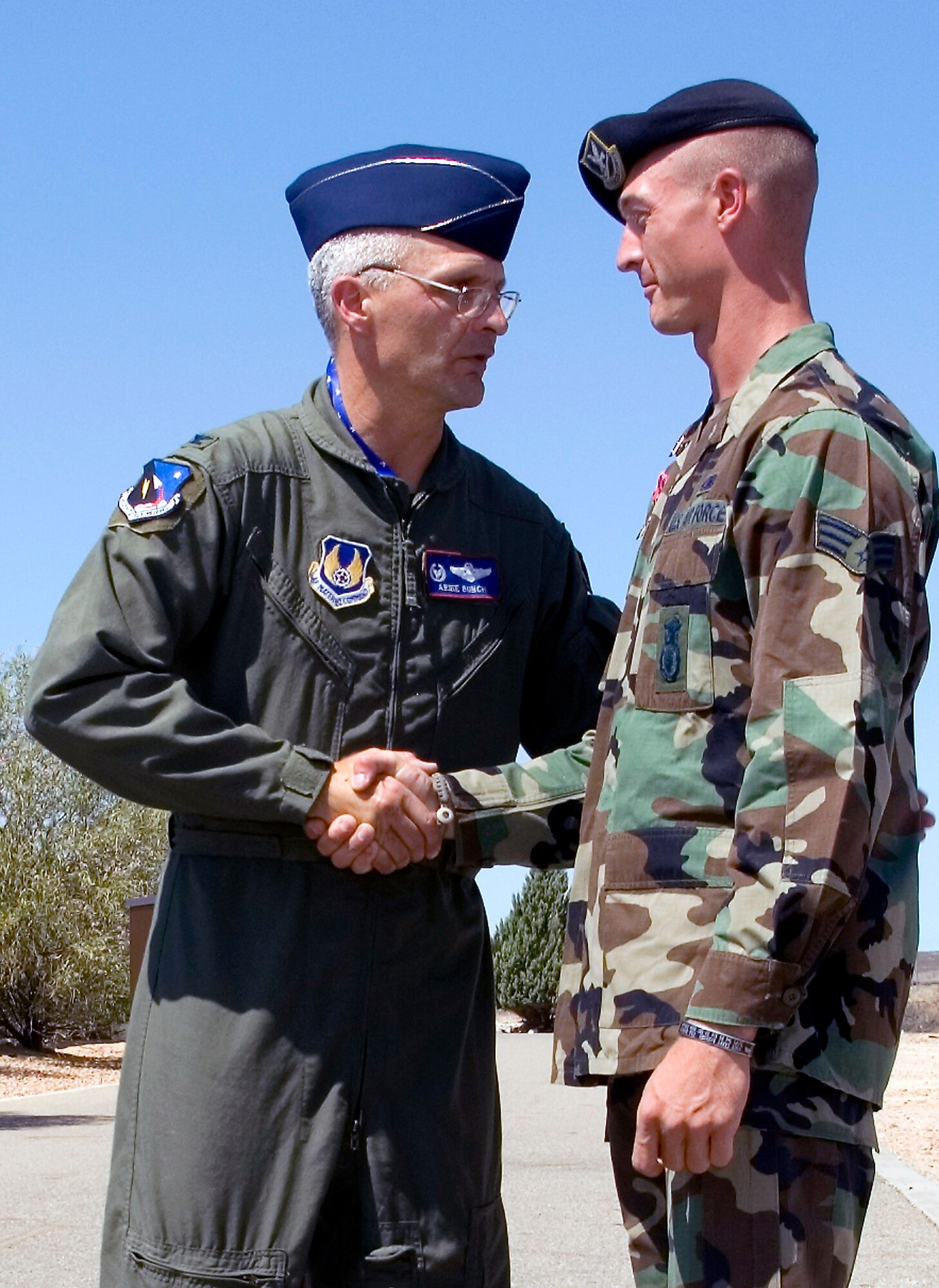 Colonel Arnie Bunch, the 412th Test Wing commander, congratulates Senior Airman Phillip King, a patrolman with the 95th Security Forces Squadron, during a July 30 ceremony at Edwards Air Force Base, Calif. Airman King received a Bronze Star Medal with Valor for his gallantry during a deployment in Afghanistan supporting Operation Enduring Freedom. (U.S. Air Force photo/Edward Cannon)