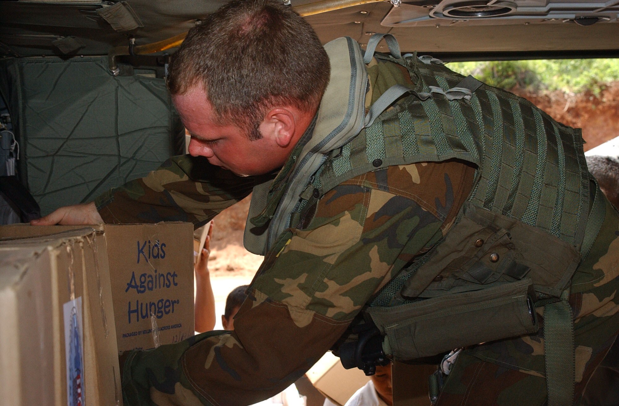 Army Staff Sgt. Adam Pasquarella, a crew chief with the 1st Battalion 228th Aviation Regiment, secures humanitarian supplies on board a UH-60 Black Hawk. Joint Task Force-Bravo provided air, ground and logistical support to the Navy's Project Handclasp. Project Handclasp is a partnership between the Navy and corporations, public service organizations, non-government organizations and individuals throughout the United States to provide humanitarian assistance overseas.  Air Force photo by Senior Airman Shaun Emery.                             